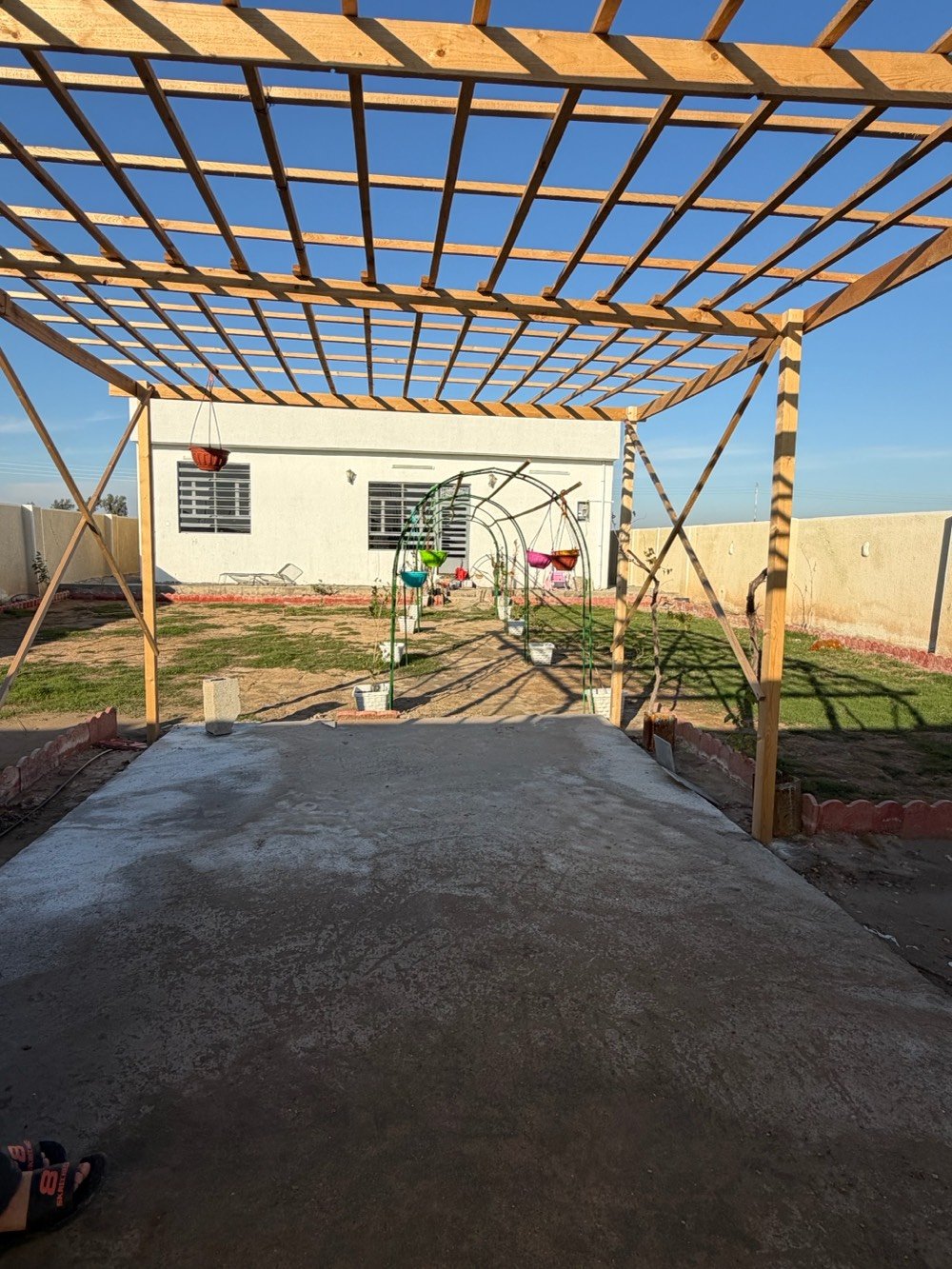 بيت في موقع هادئ ومميز مع مساحة خارجية واسعة تصلح كمكان ترفيهي أو حديقة. يتوفر فيه جلسة خارجية مشمسة مثالية لأوقات الاسترخاء، مع بنية pergola خشبية تضيف جمالية للمكان. الدار يحتوي على غرفة كبيرة, أرضية مبلطة بشكل جيد، ومجهز بجهاز تلفزيون. تصميم عصرى يوفر مساحة مريحة وواسعة للعيش.