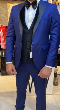 بدلة رسمية أنيقة باللون الأزرق اللامع مع صدرية وقميص أبيض وربطة عنق سو...