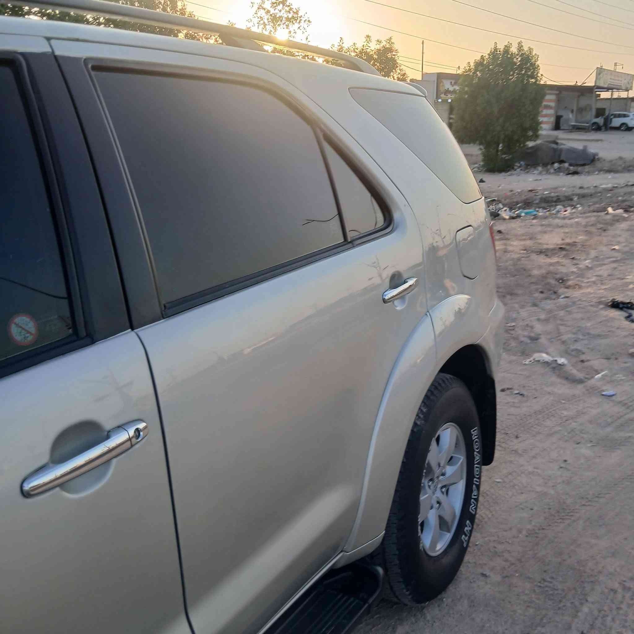 السيارة الظاهرة في الصورة "1000372575.jpg" هي تويوتا فورتشنر (Toyota Fortuner) من الجيل الأول (تحديداً الموديلات بين 2005 و 2008 قبل التحديث الأول). وهي سيارة SUV مخصصة للمهام الشاقة تعتمد على شاسيه "تويوتا هايلوكس".
إليك المواصفات الكاملة والعامة لهذا الجيل:

​1. المحرك والأداء (تأتي بخيارين رئيسيين للمحركات)

​المحرك الأول (٦ سلندر): سعة 2.7 لتر (2TR-FE) بقوة حوالي 158 حصان.

​المحرك الثاني (6 سلندر - V6): سعة 4.0 لتر (1GR-FE) بقوة حوالي 235 حصان (وهو الأكثر انتشاراً للفئات العالية).

​ناقل الحركة: آلي (أوتوماتيك) من 4 أو 5 سرعات، أو يدوي من 5 سرعات.

​نظام الدفع: دفع رباعي مستمر (4WD) مع ناقل حركة يدوي إضافي لتغيير وضعيات الدفع (الدبل الثقيل والخفيف)، وتتوفر ببعض الأسواق بدفع ثنائي خلفي فقط.

​2. الأبعاد والتصميم الخارجي

​النوع: سيارة رياضية متعددة الاستخدامات (SUV) متوسطة الحجم بـ 5 أبواب.

​المظهر الأمامي (كما في الصورة): شبك أمامي بلمسات كروم، ومصابيح أمامية هالوجين كبيرة، وكشافات ضباب سفلية مدمجة في المصد.

​الإضافات الظاهرة في الصورة: تم تركيب مصد حماية أمامي معدني (دعامية) لحماية الواجهة، وقضبان سقفية (Roof Rails).

​3. المقصورة والراحة الداخلية

​السعة: تتسع لـ 7 ركاب (ثلاثة صفوف من المقاعد).

​التكييف: نظام تكييف قوي جداً (هوائي مزدوج أمامي وخلفي لتغطية الصفوف الثلاثة).

​المقاعد: مخمل (قماش) في الفئات القياسية، وجلد في الفئات الكاملة (المواصفات العالية).

​4. الأمان والسلامة

​وسائد هوائية أمامية (Airbags) للسائق والراكب الأمامي.

​نظام فرامل مانع للانغلاق (ABS).

​هيكل صلب مخصص للطرق الوعرة وتحمل الصدمات.

​هل تود معرفة تفاصيل محددة حول فئة معينة من هذا الموديل أو قطع الغيار الخاصة به؟

السيارة الظاهرة في الصورة "1000372575.jpg" هي تويوتا فورتشنر (Toyota Fortuner) من الجيل الأول (تحديداً الموديلات بين 2005 و 2008 قبل التحديث الأول). وهي سيارة SUV مخصصة للمهام الشاقة تعتمد على شاسيه "تويوتا هايلوكس".
***********
السعر المطلوب ١٣٧٠٠٠ الف دولار مع المجال
