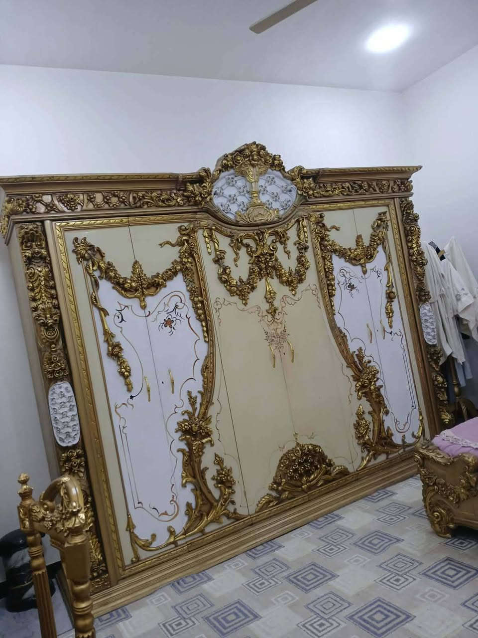 فخر الصناعة المصرية : "لعشاق الفخامة والذوق الملكي.. قطعة أثاث مميزة متوفرة الآن" التصميم: غرفة نوم موديل ملكي، تتميز بنقوش يدوية بارزة (دمياطي أو كلاسيك ثقيل) باللون الذهبي المطعم بالأبيض العاجي.
​السرير (التاج): يتميز بتاج عالٍ جداً بنقوش مفرغة وفخمة، مع تنجيد "كابيتونيه" باللون الأبيض لإعطاء راحة وشكل ملكي.
​الكنتور (الدولاب): ضخم جداً (جامب) مع مرايا جانبية ونقوش ذهبية تمتد على كامل الأبواب، مما يعطي إيحاءً بالاتساع والرقي.
​ميز التواليت: تصميم فريد بمرآة كبيرة وإطار ذهبي مزخرف، مع سطح رخامي  يضيف لمسة من الفخامة.
​الملحقات: الغرفة كاملة تشمل الكومودينات الجانبية والمقعد (البوف) الخاص بميز التواليت بنفس التصميم والنقش.
*********** وتساب السعر ١٥٠٠
