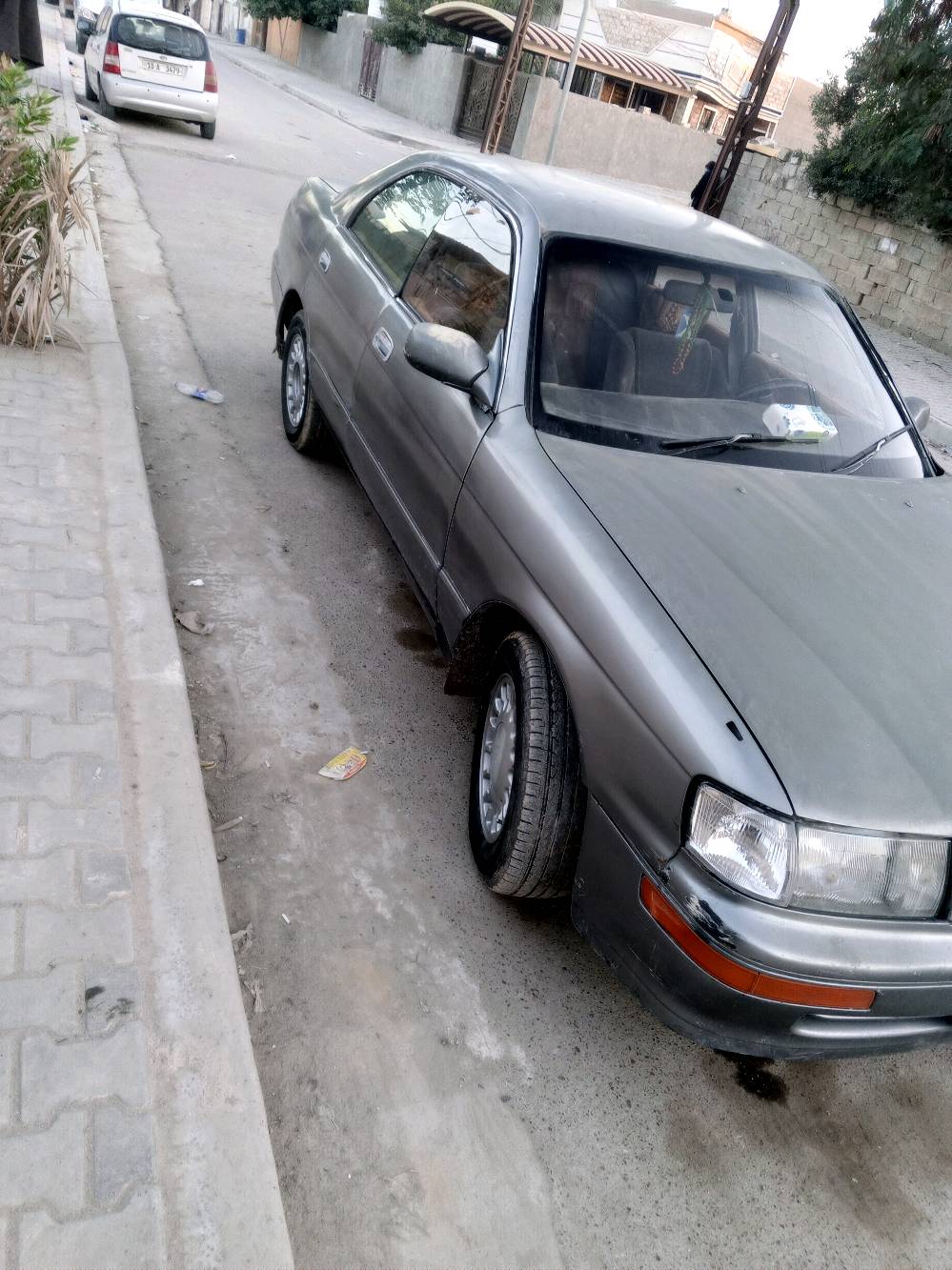 السيارة المعروضة للبيع هي من نوع تويوتا موديل قديم. لون السيارة رمادي ومظهرها العام نظيف وجاهزة للاستخدام. تحتوي السيارة على مقاعد قماشية ولوحة قيادة عملية مع مقود مغطى.

السيارة ذات ناقل حركة أوتوماتيك وتتوفر فيها العديد من المزايا التقليدية لهذه الفئة العمرية. تعد خياراً اقتصادياً لمن يبحث عن سيارة مستعملة تؤدي الغرض بأسعار معقولة.