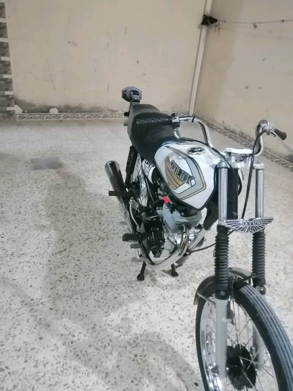 دراجة نارية من نوع دايون، تصميم كلاسيكي وأنيق باللون الأبيض. الدراجة في حالة جيدة ومناسبة للاستخدام داخل المدينة أو المسافات القصيرة. مناسبة لعشاق الدراجات الكلاسيكية وتوفر قيادة مريحة.