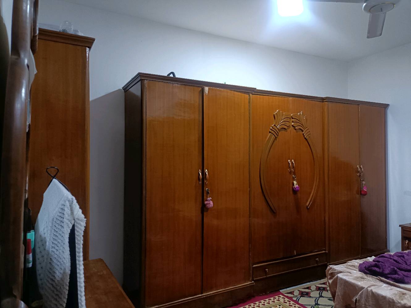 غرفة نوم خشبية بحالة جيدة تتكون من سرير مزدوج بألواح رأس مزخرفة، دولابات متعددة الاستخدام، وتسريحة بمرايا كبيرة. مناسبة لمن يبحث عن تصميم كلاسيكي وأداء وظيفي.