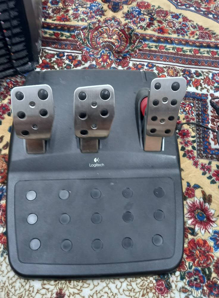 لحد 900 درجة مثل السيارة الحقيقية �
Wikipedia +1
⚙️ Force Feedback:
يحتوي على محركين Dual-Motor حتى تحس بالطريق والاهتزاز والتفحيط بشكل واقعي �
HEXUS.net +1
🔇 نوع التروس:
Helical Gears
يعني صوت أنعم وأهدأ من G25 �
Wikipedia +1
🛞 الدركسون:
مقاس 27 سم تقريبًا
جلد حقيقي (Leather Wrapped) �
Wikipedia +1
🦶 البدالات:
3 بدالات:
بنزين
بريك
كلتش
ومصنوعة من الستانلس ستيل �
Wikipedia +1
🕹️ القير:
قير يدوي H-Pattern
6 سرعات + ريوس (Reverse) �
Wikipedia +1
🎯 أزرار:
أزرار على الدركسون والقير
Paddle Shifters خلف الدركسون �
Wikipedia
🔌 التوصيل:
USB + محول كهرباء خارجي بغداد, العراق


**إذا كنت صاحب هذا الإعلان وتريد حذفه لأي سبب، رجاءا أرسل رسالة إلى الدعم الفني**