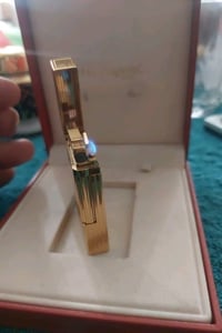 هذه ولاعة S.T. Dupont Ligne 2 مطلية بالذهب الأصفر وتتميز بزخارف عمودية...