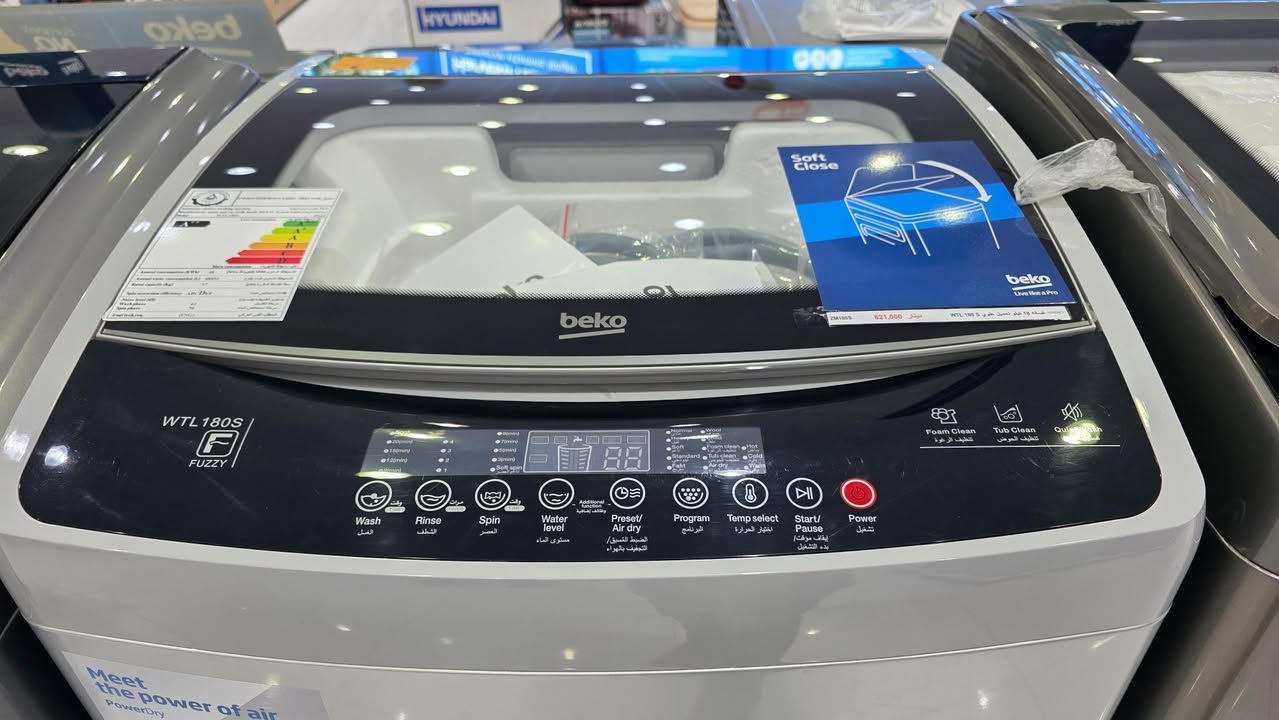 عرض خاص يمنا فقط وكمية محدودة حالياا 👌 بيكو (**Beko**).
 * **الموديل:** **WTL180S** (يظهر بوضوح بجانبه شعار تقنية **FUZZY** للتحكم الذكي).
 * **نوع الغسالة:** غسالة ملابس **فوق أوتوماتيك (تحميل علوي - Top Load)**.
 * **اللون:** رمادي فضي (Silver/Grey) عصري وأنيق يتناسب مع مختلف الديكورات الحديثة.
 * **الباب العلوي:** يتميز بوجود زجاج شفاف يتيح رؤية الملابس بالداخل أثناء الغسيل، ومزود بتقنية **Soft Close** (الإغلاق الهادئ والآمن لحماية الباب من الصدمات).
### 2. لوحة التحكم والبرامج (Control Panel)
اللوحة رقمية بالكامل تعمل باللمس وتأتي باللغتين العربية والإنجليزية لسهولة الاستخدام، وتتضمن الخيارات التالية:
 * **شاشة عرض رقمية (LED):** تظهر الوقت المتبقي وحالة البرنامج الحالي.
 * **أزرار التحكم الأساسية:** * الغسيل (**Wash**)، الشطف (**Rinse**)، العصر (**Spin**).
   * مستوى الماء (**Water level**).
   * ضبط مسبق / تجفيف بالهواء (**Preset / Air dry**) للحصول على تجفيف إضافي فعال.
   * اختيار البرنامج (**Program**) واختيار درجة الحرارة (**Temp select**).
   * أزرار التشغيل الرئيسية: البدء/المؤقت (**Start/Pause**) وزر الطاقة (**Power**).
 * **ميزات خاصة مدمجة:** * تنظيف الرغوة (**Foam Clean**).
   * تنظيف الحوض (**Tub Clean**) للحفاظ على نظافة الغسالة من الرواسب.
   * الغسيل الهادئ (**Quiet Wash**) لتقليل الضوضاء والاهتزاز.
### 3. التصميم الداخلي والحلة (الحوض)
 * **الحلة الداخلية:** مصنوعة من **الاستانلس ستيل (Stainless Steel)** المقاوم للصدأ عالي الجودة، وتأتي بتصميم بارز (شبه الماسي) لحماية الأقمشة الحساسة من التلف وزيادة كفاءة التنظيف.
 * **المروحة السفلية:** مروحة قوية مصممة لتوليد تيارات مائية متطورة لمنع تشابك الملابس وتوزيع المسحوق بشكل مثالي.
 * **مداخل المنظفات:** تحتوي على درج مخصص مقسم لإضافة المسحوق (**Detergent**) ومنعم الأقمشة (**Softener**).
### 4. كفاءة الطاقة والملصقات الإرشادية
 * **ملصق كفاءة الطاقة:** يظهر على الغسالة ملصق تقييم استهلاك الطاقة (بالمستويات الملونة)، مما يشير إلى توافقها مع معايير توفير استهلاك الكهرباء والماء.
 * **شعار "Meet the power of air":** ملصق أمامي يبرز تقنية الاعتماد على تدفق الهواء (**PowerDry**) للمساعدة في تجفيف الملابس بشكل أسرع وأكثر كفاءة.
👇✅️للحجز والاستفسار يرجى مراسلة الصفحة الرئيسية او اتصال و اتساب على أرقام التالية 
***********
***********
 https://www.facebook.com/share/1CMd7FzpkH/
العنوان /💎✅️ معرض الجوهرة ✅️💎
موصل / حي القادسية الثانية مقابل بدالة الزهور مجاور مول الكوثر 
***********
***********
