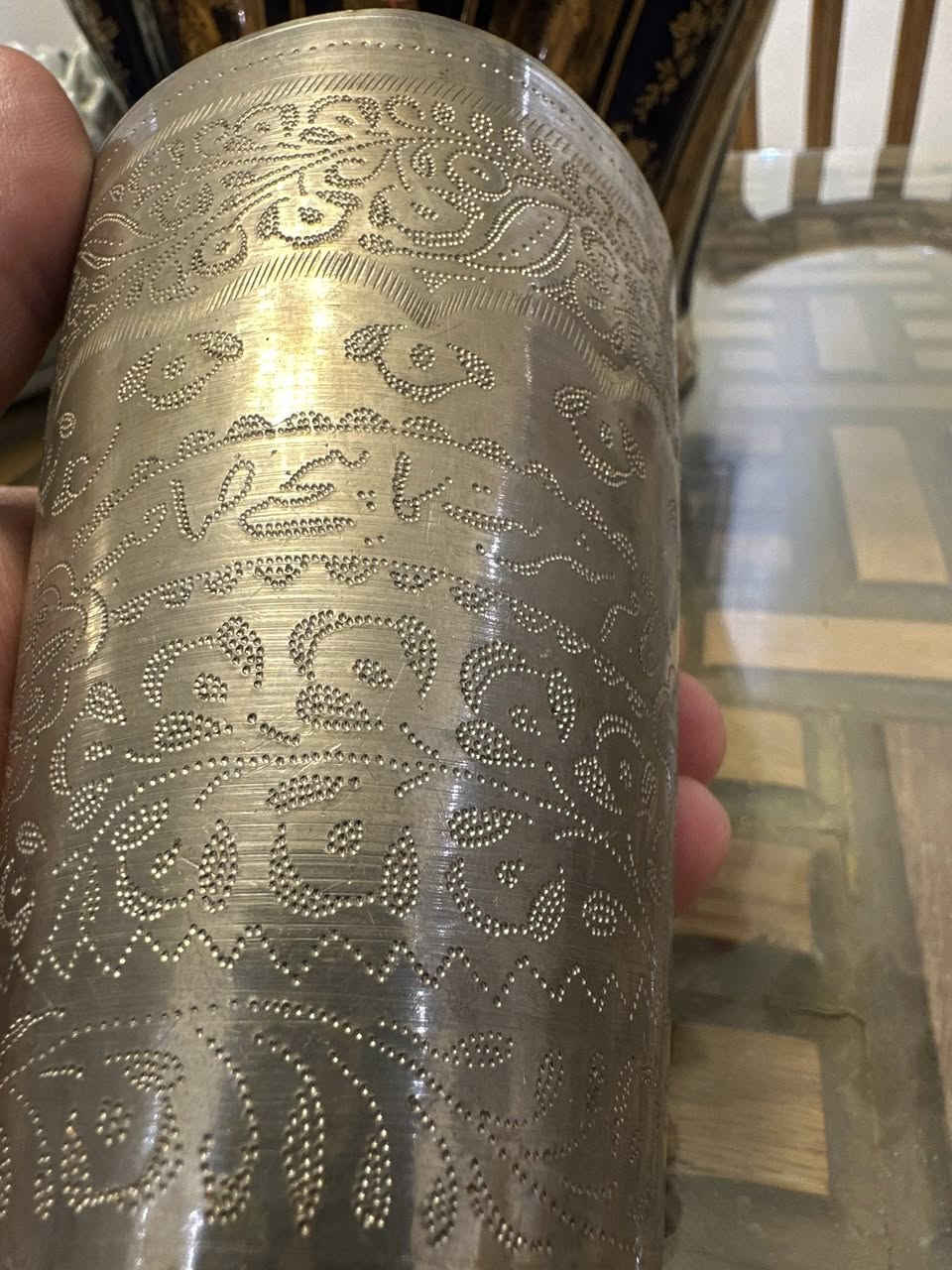 القطعة هي كوب "لاسي" (Lassi Cup) تقليدي، وهو نوع من الأكواب المنتشرة في جنوب آسيا والشرق الأوسط، وتُستخدم عادةً لتقديم المشروبات التقليدية أو كقطع ديكور
 القطعة مصنوعة من النحاس الأصفر (Brass) أو مزيج من القصدير والفضة الألمانية (German Silver)، وغالباً ما تكون مطلية بطبقة فضية لإعطائها هذا المظهر اللامع.
الزخرفة: تتميز بنقوش يدوية دقيقة (Hand Etched) تعتمد على تقنية التنقيط والخطوط المحفورة. الزخارف نباتية وهندسية تتسم بطابع تراثي شرقي أو فارسي.

السعر ٦٠,٠٠٠ دينار 
للاستفسار ***********
