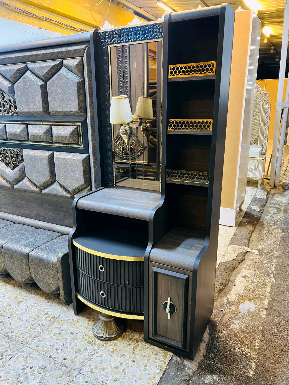 غرفة نوم مودرن وجديدة للبيع، تتميز بتصميم راقي وأنيق بلون رمادي مع لمسات ذهبية. تحتوي الغرفة على خزانة ملابس واسعة مع مرايا، وتسريحة مع أدراج ووحدات تخزين متعددة بالإضافة إلى طاولات جانبية بتصميم جمالي لتكمل الديكور. تناسب مختلف الأذواق وتضيف لمسة من الفخامة لأي منزل.