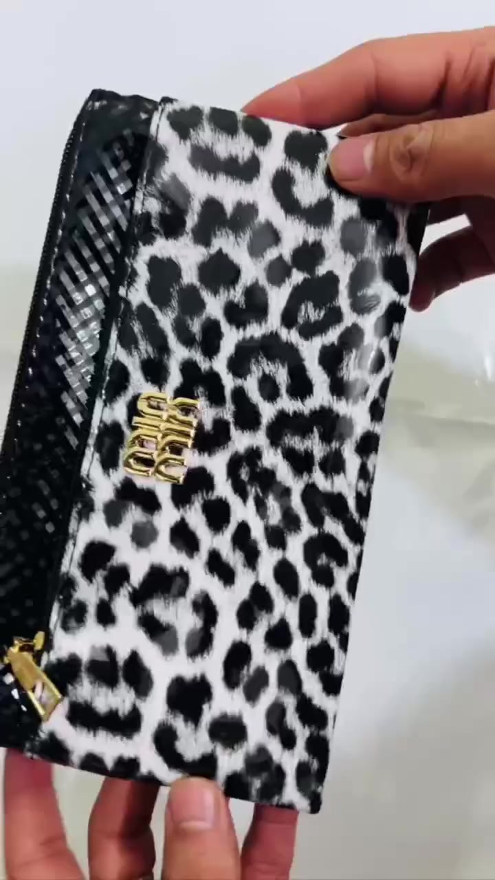 حقيبة كلاتش (Clutch) بنقشة جلد النمر. 
تتميز الحقيبة بالتالي:
التصميم: تأتي بنقشة جلد النمر (Leopard Print) باللونين الأبيض والأسود، مع جزء علوي أسود اللون.
الشعار: يتوسطها شعار ذهبي بارز.
الإغلاق: مزودة بسحاب علوي باللون الذهبي.
الاستخدام: تُستخدم عادةً كحقيبة يد صغيرة للمناسبات أو كحقيبة لتنظيم المكياج والمقتنيات الصغيرة داخل حقيبة أكبر.


**إذا كنت صاحب هذا الإعلان وتريد حذفه لأي سبب، رجاءا أرسل رسالة إلى الدعم الفني**