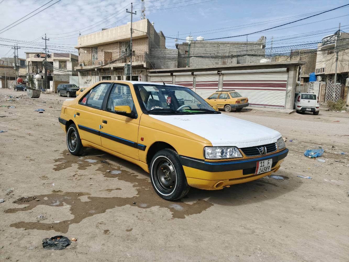 السيارة المعروضة للبيع هي بيجو بلون أصفر مع إكسسوارات زرقاء وسقف أبيض مميز. المقاعد مُغطاة بواقٍ بلاستيكي للحفاظ على النظافة، والمقود مُغطى بتغليف لضمان حماية إضافية. السيارة تبدو في حالة جيدة ولا توجد أضرار ظاهرة في الهيكل الخارجي أو الداخلي. الصندوق الخلفي واسع وكافٍ لحمل الأغراض. هذه السيارة مثالية للاستخدام اليومي أو للأعمال بفضل حالتها المحافظة والتجهيزات الأساسية المتوفرة فيها.