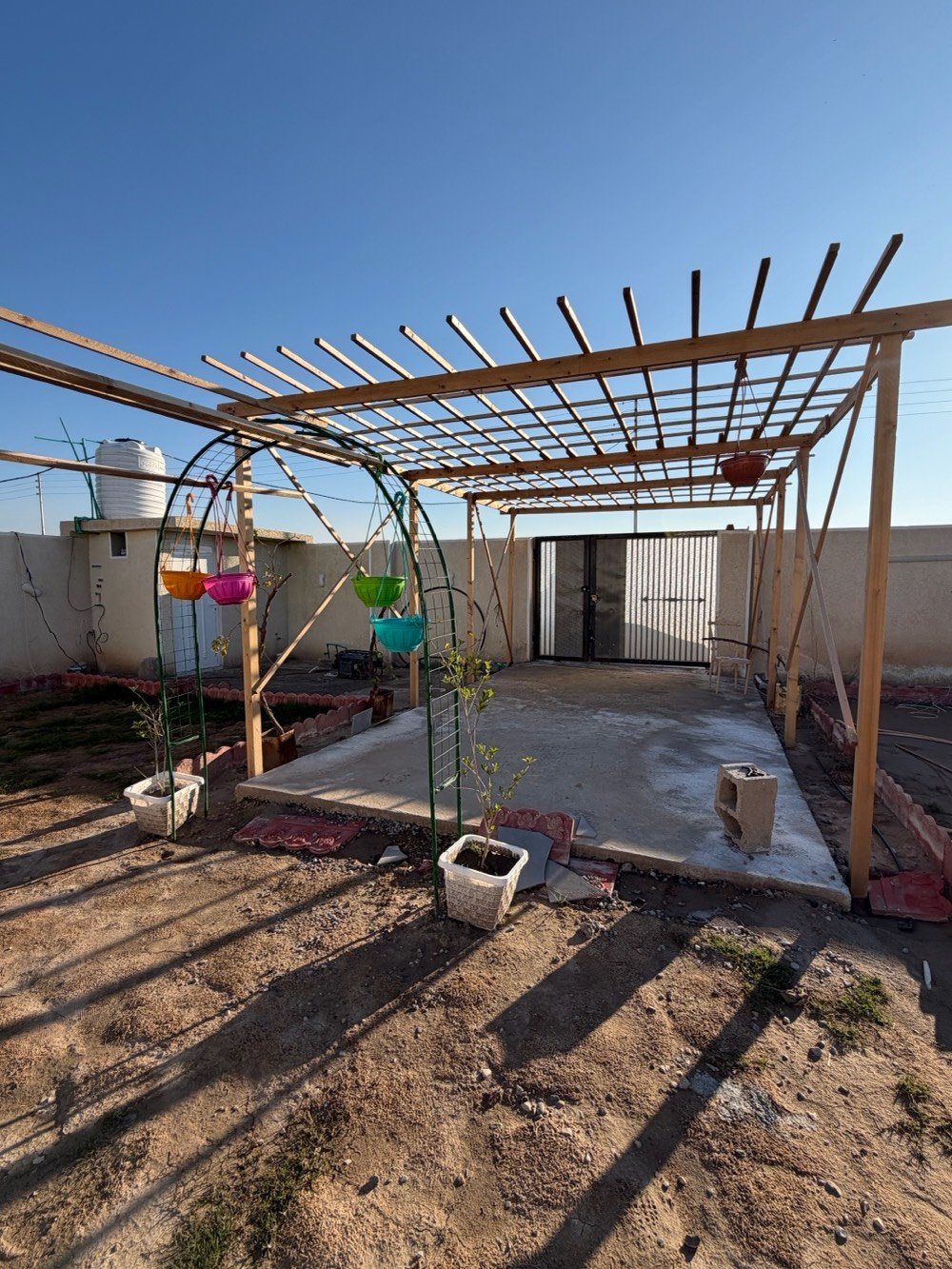 بيت في موقع هادئ ومميز مع مساحة خارجية واسعة تصلح كمكان ترفيهي أو حديقة. يتوفر فيه جلسة خارجية مشمسة مثالية لأوقات الاسترخاء، مع بنية pergola خشبية تضيف جمالية للمكان. الدار يحتوي على غرفة كبيرة, أرضية مبلطة بشكل جيد، ومجهز بجهاز تلفزيون. تصميم عصرى يوفر مساحة مريحة وواسعة للعيش.