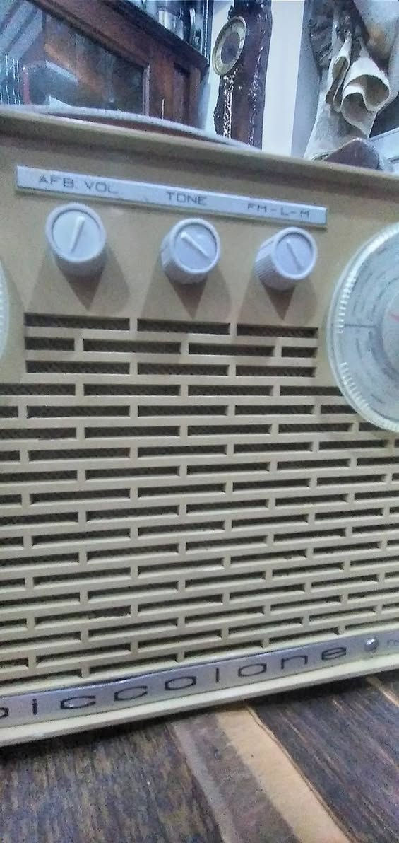 جهاز  راديو ترانزستور كلاسيكي نادر من طراز Piccolone،  من إنتاج شركة SABA الألمانية العريقة (غالباً موديل من أوائل الستينيات). يتميز هذا الراديو بتصميمه الذي يجمع بين البساطة الهندسية والفخامة التقنية لتلك الحقبة.
​إليك التفصيل الفني والجمالي لهذه القطعة:
​ المواصفات التقنية (من الواجهة)
​نظام الترانزستور: مكتوب عليه "10 Transistor"، وهو ما كان يعتبر طفرة تقنية في وقته، حيث تضمن هذه الترانزستورات جودة التقاط عالية وصوت نقي مقارنة بالأجهزة الأقدم.
​الموجات والترددات:
​الميناء الأيسر: مخصص لموجة الـ FM (ترددات من 88 إلى 104 ميجاهرتز).
​الميناء الأيمن: مخصص للموجات الطويلة والمتوسطة (LW/MW).
​أدوات التحكم: يحتوي على ثلاثة مفاتيح في المنتصف:
​AFB VOL: للتحكم في التشغيل ومستوى الصوت.
​TONE: للتحكم في حدة الصوت (Bass/Treble).
​FM-L-M: مفتاح التنقل بين الموجات الثلاث.
​2. التصميم الخارجي
​الهيكل: مصنوع من البلاستيك المقوى (Bakelite أو بلاستيك عالي الجودة) بلون "كريمي" أو بيج فاتح، مع مقبض علوي جلدي مريح للحمل.
​الشبكة الأمامية: صُممت بشكل خطوط عرضية متقطعة تسمح بخروج الصوت بوضوح وتمنحه مظهراً كلاسيكياً (Retro).
​الميناء (Dials): الأقراص الدائرية الكبيرة شفافة مع مؤشرات حمراء دقيقة، وهي علامة مميزة لتصاميم الستينيات الأوروبية.
​ القيمة التاريخية
​علامة SABA الألمانية كانت منافساً قوياً لشركات مثل "تيلفونكن" و"جرونديج"، وتعتبر أجهزتها اليوم من القطع المرغوبة جداً لدى هواة جمع الأنتيك لجودة صناعتها وطول عمرها الافتراضي.
​يُطلق عليه اسم "Super" (مكتوب في الزاوية اليمنى السفلى)، وهي إشارة إلى تقنية "Superheterodyne" في استقبال الإشارات اللاسلكية.
​نصيحة للعناية بالقطعة:
​بما أن الهيكل من البلاستيك القديم، يُفضل تنظيفه بقطعة قماش ناعمة مبللة قليلاً بالماء وتجنب المنظفات الكيميائية القوية التي قد تتسبب في بهتان اللون أو تشقق البلاستيك.


**إذا كنت صاحب هذا الإعلان وتريد حذفه لأي سبب، رجاءا أرسل رسالة إلى الدعم الفني**