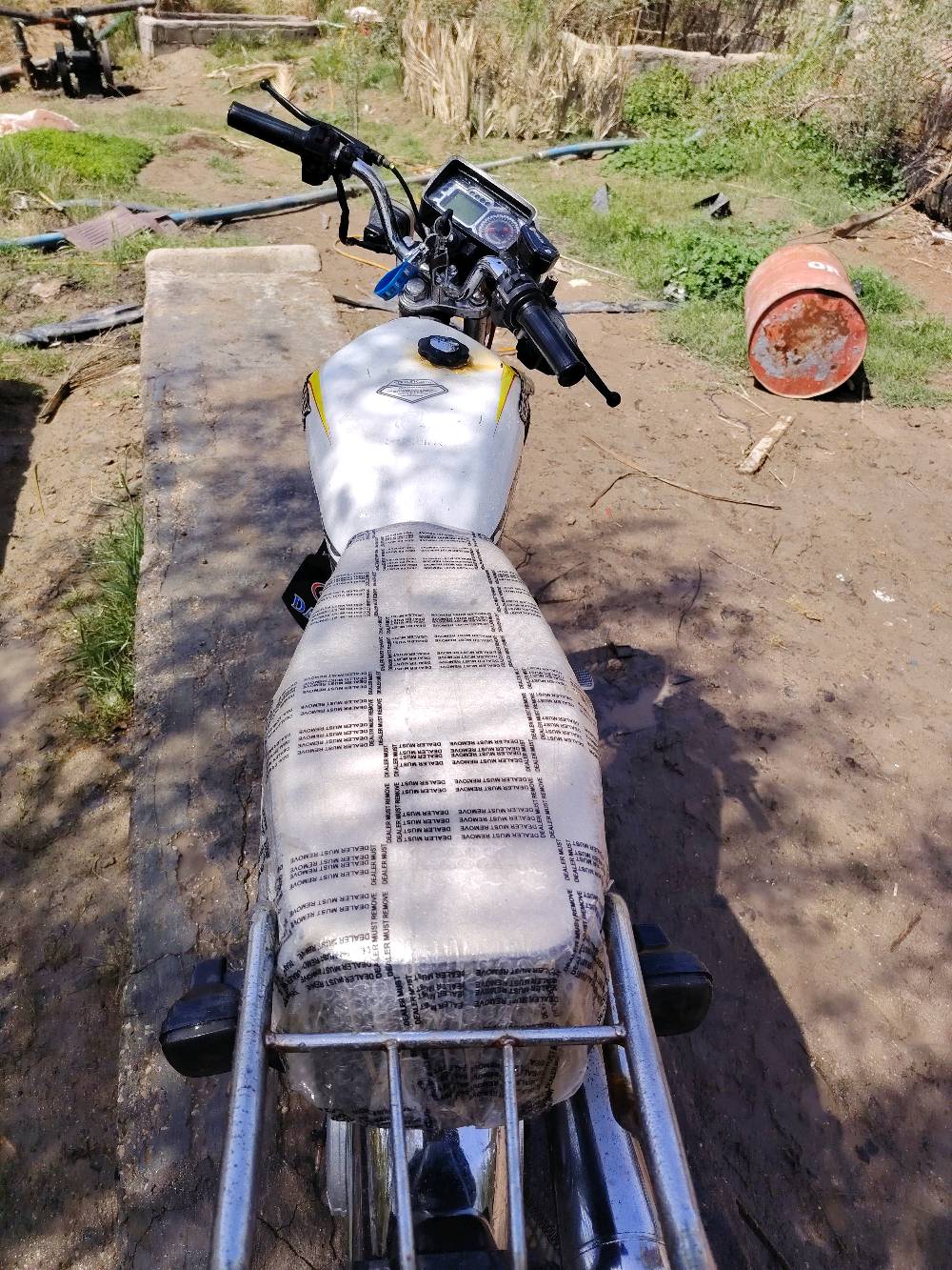 دراجة نارية نوع دايون CG125 بحالة ممتازة، لونها أبيض مع رسومات جانبية. الدراجة نظيفة ومجهزة بالكامل، مما يجعلها مثالية للاستخدام اليومي أو المشاوير الطويلة.