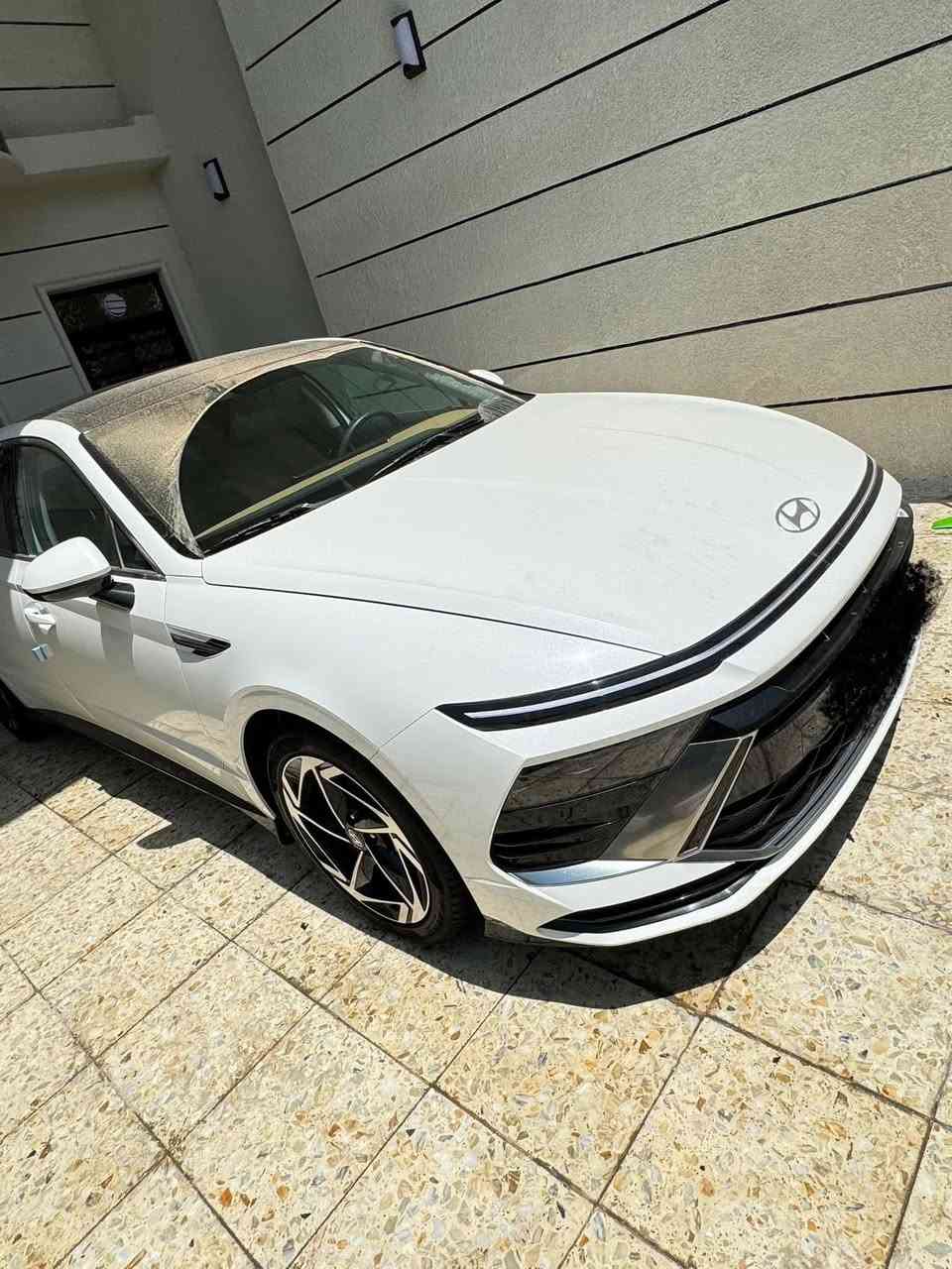 سوناتا 2024  ( خـليـجـي ) بعدها زيرو  بريحه الشركه  كفاله رقم بغداد بسمي عامه ماشيه 9000
الأداء والمحرك (المواصفات القياسية)
• المحرك: 4 أسطوانات (Smartstream) سعة 2.5 لتر.
• القوة الحصانية: حوالي 191 - 194 حصان.
• عزم الدوران: 245 نيوتن متر.
• ناقل الحركة: أوتوماتيكي بـ 8 سرعات.
• نظام الدفع: دفع أمامي (FWD).
• استهلاك الوقود: موفرة جداً، بمعدل تقريبي 16.3 كم/لتر (يختلف قليلاً حسب ظروف القيادة).
2. التصميم الخارجي
• الإضاءة: تتميز بشريط إضاءة LED ممتد في المقدمة يسمى "Seamless Horizon Lamp" يمنحها مظهراً مستقبلياً.
• المصابيح: مصابيح أمامية LED (نوع MFR) وإضاءة خلفية LED متصلة.
• الجنوط: تأتي بقياس 16 أو 17 بوصة من الألمنيوم في الفئة القياسية.
• المرايا: جانبية كهربائية مدمج بها إشارات انعطاف LED.
3. المقصورة والتقنيات الداخلية
• الشاشات: شاشة معلومات وترفيه تعمل باللمس مقاس 12.3 بوصة (أو 8 بوصة في بعض الأسواق لنسخ الفليت)، تدعم Apple CarPlay و Android Auto.
• لوحة العدادات: رقمية بسيطة مقاس 4.2 بوصة LCD تتوسط العدادات التقليدية.
• المقاعد: مكسوة بالقماش عالي الجودة مع تحكم يدوي أو كهربائي بسيط لمقعد السائق.
• التكييف: نظام تكييف هواء يدوي مع فتحات تهوية خلفية.
4. أنظمة السلامة والأمان (Standard)
تتميز سوناتا بأنها توفر حزمة أمان جيدة حتى في أقل فئة:
• وسائد هوائية أمامية مزدوجة (للسائق والراكب).
• نظام تثبيت السرعة (Cruise Control).
• حساسات ركن خلفية للمساعدة في الاصطفاف.
• نظام منع انغلاق المكابح (ABS) وتوزيع قوة الفرامل إلكترونياً (EBD).
• نظام مراقبة ضغط الإطارات (TPMS).
ماشيه9000km 
مكان السياره بغداد 
الاستفسار

‭0771 467 3844‬
