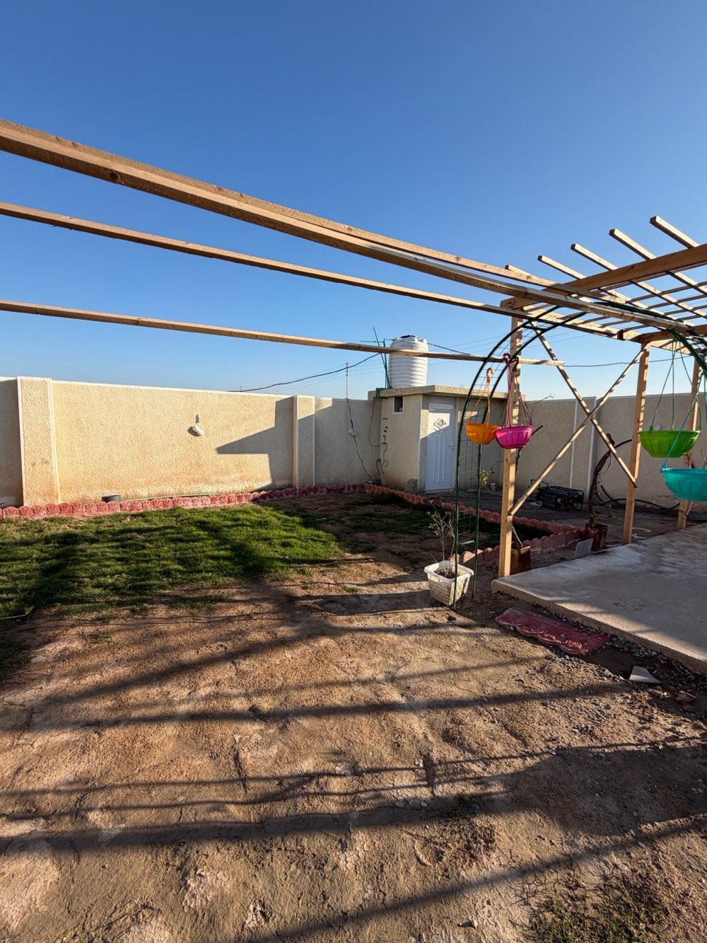 بيت في موقع هادئ ومميز مع مساحة خارجية واسعة تصلح كمكان ترفيهي أو حديقة. يتوفر فيه جلسة خارجية مشمسة مثالية لأوقات الاسترخاء، مع بنية pergola خشبية تضيف جمالية للمكان. الدار يحتوي على غرفة كبيرة, أرضية مبلطة بشكل جيد، ومجهز بجهاز تلفزيون. تصميم عصرى يوفر مساحة مريحة وواسعة للعيش.