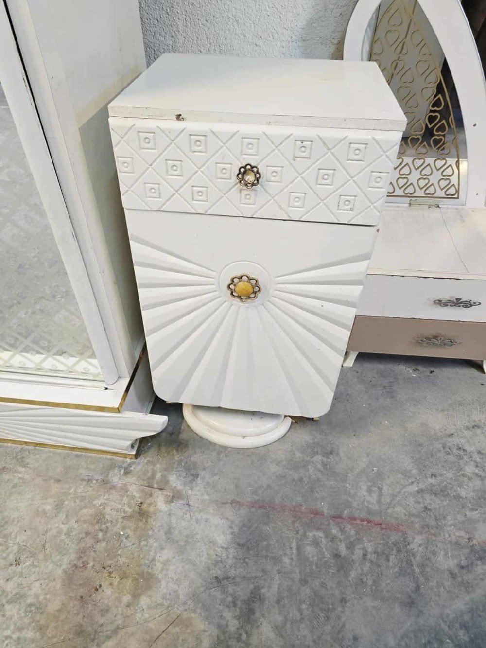 غرفة نوم فاخرة تصميم كلاسيكي، تتضمن سرير كبير مع خلفية منجدة بتفاصيل زخرفية جذابة باللون الأبيض، بالإضافة إلى خزانة ملابس مرايا وشيفونيرة مع أدراج واسعة. التصميم يتميز بالنقوش الكلاسيكية التي تضيف لمسة من الأناقة والرقي للغرفة. الأثاث بحالة جيدة ويضفي لمسة فاخرة على أي غرفة النوم.