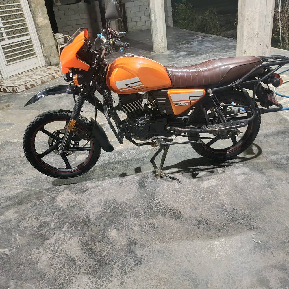 دراجة نارية برتقالية اللون بحالة جيدة جداً، مثالية للاستخدام اليومي والتنقل. تحتوي على حقيبة تخزين خلفية كبيرة، ممتازة لتوصيل الطرود أو استخدامات المتعددة. تمتاز بمقعد مريح وتصميم عصري. السعر منافس ومناسب لمن يبحث عن أداء عالي بأسعار معقولة.