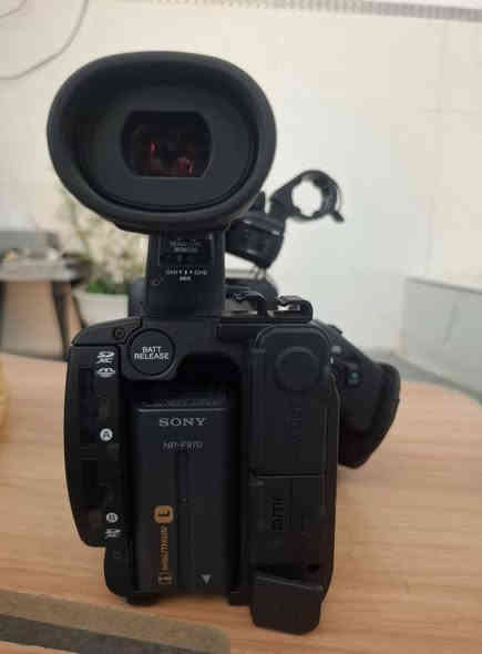 ✅ الموديل  Sony HXR-MC2500

🎥 أهم المواصفات الفنية للكاميرا Sony HXR-MC2500

🔹 المستشعر (Sensor)

نوع المستشعر: Exmor R CMOS

الحجم: 1/4 بوصة

أداء جيّد في الإضاءة المنخفضة مقارنةً بكاميرات الفئة نفسها.

🔹 العدسة (Lens)

تكبير بصري 15× (واضح على العدسة في صورك).

بعد بؤري: 29.8mm إلى 447mm (مكافئ 35mm).

فتحة عدسة: f/1.8 – f/3.4.

🔹 نظام التسجيل (Recording)

يسجّل فيديو بصيغة AVCHD 2.0.

دقة التصوير:

1920×1080 (Full HD) بمعدل 50p / 50i.

1280×720 حسب الإعدادات.

وسائط التخزين:

ذاكرة داخلية 32GB.

منفذ بطاقة SD/SDHC/SDXC.

🔹 الصوت (Audio)

مدخل مايكروفون XLR احترافي (غالبًا يكون في النسخة الكاملة مع حامل المايك).

تسجيل صوت Dolby Digital.

تحكم يدوي بمستوى الصوت (واضح على لوحة التحكم في الصور).

🔹 الشاشة والبحث (Viewfinder & LCD)

شاشة قابلة للطي بحجم 3.0 بوصة.

منظار إلكتروني EVF قابل للتعديل.

🔹 مميزات أخرى

مثبت بصري Optical SteadyShot.

خيار NightShot للتصوير الليلي بالأشعة تحت الحمراء.

بطاريات كبيرة من نوع NP-F (الصور تظهر عدة بطاريات وشاحن Sony أصلي).

📦 الملحقات 

2 بطاريات Sony NP-F.

شاحن أصلي مزدوج.
حقيبة sony أصلية .

شاشة الكاميرا مفتوحة.

حامل كتف مدمج (Shoulder Mount Style).

✅ مزاياها للاستخدام الإعلامي / الصحفي

1. جودة فيديو عالية:

تسجّل بدقة Full HD (1080p) بصيغة AVCHD، وهي مناسبة للتغطيات الإخبارية والفيديو الصحفي. 

2. أداء جيد في الإضاءة المنخفضة:

المستشعر Exmor R يمكنه العمل عند إضاءة منخفضة (حتى 0.8 لوكس في وضع SD) حسب المواصفات. 

يوجد ضوء LED مدمج في الكاميرا، ما يساعد عند التصوير في أماكن مظلمة. 

3. استقرار التصوير:

تصميم الكتف (shoulder-mount) يمنح استقرارًا جيدًا للتصوير اليدوي، وهو مهم جدًا عند تغطية أحداث ميدانية، مؤتمرات، أو مقابلات. 

4. صوت احترافي:

التحكم اليدوي في الصوت موجود (كما رأينا في مواصفاتها)، ويمكن استخدام مايكروفونات احترافية (XLR في بعض نسخ الكاميرا) — مهم جدًا للتسجيل الصحفي حيث جودة الصوت ضرورة.

بعض العروض تتضمن مايكروفون مثل Audio-Technica مرفق. 

5. ارتباط لاسلكي وتحكم:

تدعم Wi-Fi للتحكم عن بعد أو المراقبة. 

6. ذاكرة داخلية + بطاقات خارجية:

تحتوي على ذاكرة داخلية (حسب بعض المصادر)، بالإضافة إلى إمكانية استخدام بطاقات SD لتخزين إضافي.
مخصصة للعاملين في:
مجال الإعلام والصحافة 

تصوير الأعراس

الفيديو الوثائقي

تغطية الفعاليات

تسجيل الخطب والمحاضرات
السعر  مليون وخمسمائة ألف دينار كاميرا جديدة غير مستخدمة
الإتصال على الوتساب *********** أو وتساب *********** العنوان كربلاء المقدسة شارع أبو طالب .
