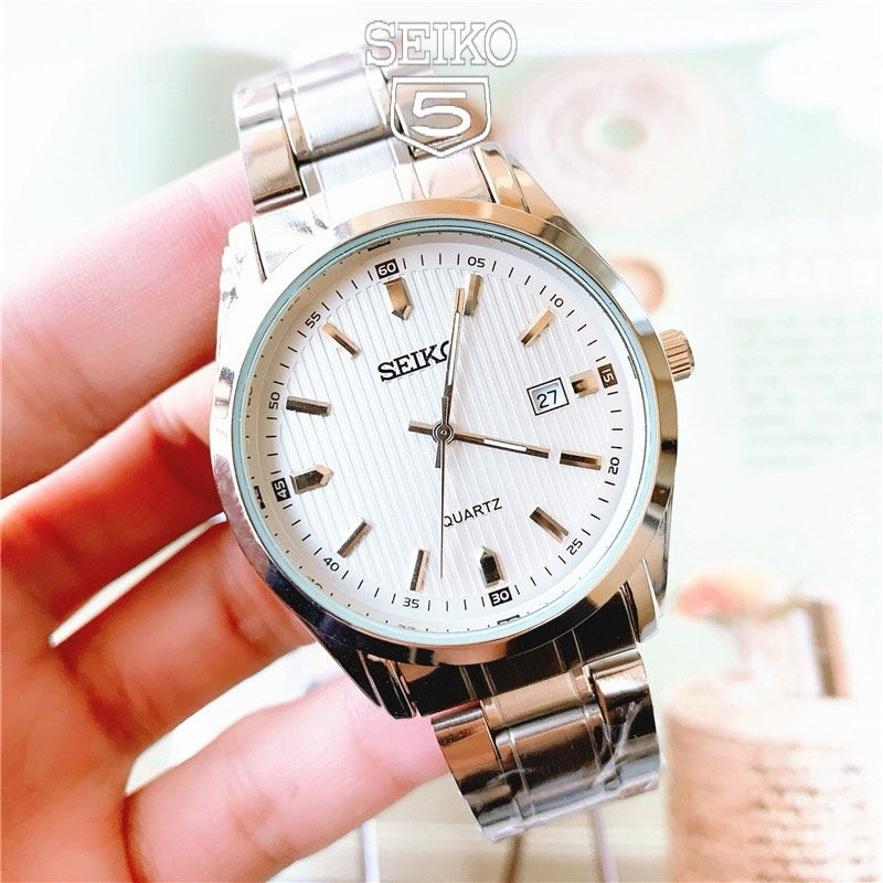 الساعة هي من طراز سيكو (Seiko) وتحديداً فئة الـ Quartz الكلاسيكية. إليك أبرز مميزاتها وخصائصها بناءً على ما يظهر في الصورة:
1. التصميم الجمالي
• الميناء (Dial): يتميز بنمط "الخطوط الطولية" (Vertical Pinstripe)، وهو تصميم يمنح الساعة مظهراً فخماً يذكرنا بساعات "أوميغا أكوا تيرا"، مما يجعلها مناسبة للمناسبات الرسمية واليومية.
• عقارب ومؤشرات واضحة: المؤشرات (Markers) بارزة ومصقولة، مما يسهل قراءة الوقت بوضوح تحت الإضاءة المختلفة.
• هيكل كلاسيكي: الهيكل مصنوع من الفولاذ المقاوم للصدأ (Stainless Steel) بتصميم يجمع بين الأسطح اللامعة والمطفأة.
2. المواصفات التقنية
• حركة الكوارتز (Quartz): تعمل ببطارية، وهي معروفة بدقة متناهية في حفظ الوقت مقارنة بالساعات الميكانيكية، كما أنها تتطلب صيانة أقل بكثير.
• نافذة التاريخ: توجد نافذة لعرض التاريخ عند موضع الساعة 3، وهي ميزة عملية للاستخدام اليومي.
• سوار معدني: تأتي بسوار متصل (Link Bracelet) متين، وهو أكثر استدامة ومقاومة للتعرق والماء من الجلود.
3. الموثوقية والعملية
• العلامة التجارية: سيكو هي شركة رائدة عالمياً، وساعاتها معروفة بأنها "تخدم طويلاً" وتتحمل الاستخدام الشاق.
• تعدد الاستخدامات: بفضل لونها الفضي ومينائها الأبيض، تتماشى هذه الساعة مع معظم ألوان الملابس (رسمي، كاجوال، أو بدلة عمل).


**إذا كنت صاحب هذا الإعلان وتريد حذفه لأي سبب، رجاءا أرسل رسالة إلى الدعم الفني**