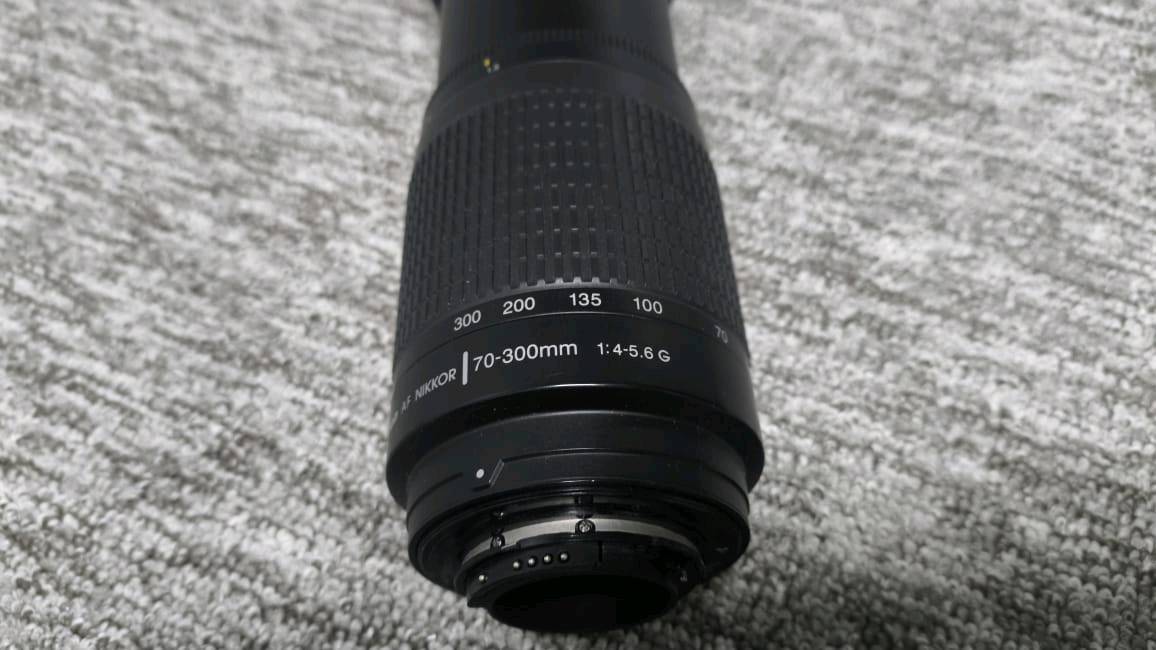 زوم رياضي 70-300
نيكون من شركة نيكور
يرهم لكامرات نيكون الفئات المتوسطة
فئة ال7000 الى 7600 ونيكون 610
والكثير من الكامرات بمثل هذه المواصفات 
بلمختصر المفيد ترهم على الكامرات الي تحتوي
على نضام AF فقط
.
مواصفات العدسة ""
البعد البؤري (Focal Length): من 70mm إلى 300mm (عدسة زوم وتقريب ممتازة لالتقاط الأشياء البعيدة، والطيور، والرياضة، وحتى البورتريه).نوع العدسة: G-type (تتحكم بفتحة العدسة من خلال جسم الكاميرا نفسه، ولا تحتوي على حلقة ميكانيكية خارجية للفتحة).f/4 عند البعد البؤري 70mm
f/5.6 عند البعد البؤري 
300mm
.
للاستفسار اكثر ***********
وضروري تنطينـي اسـم كامرتــك