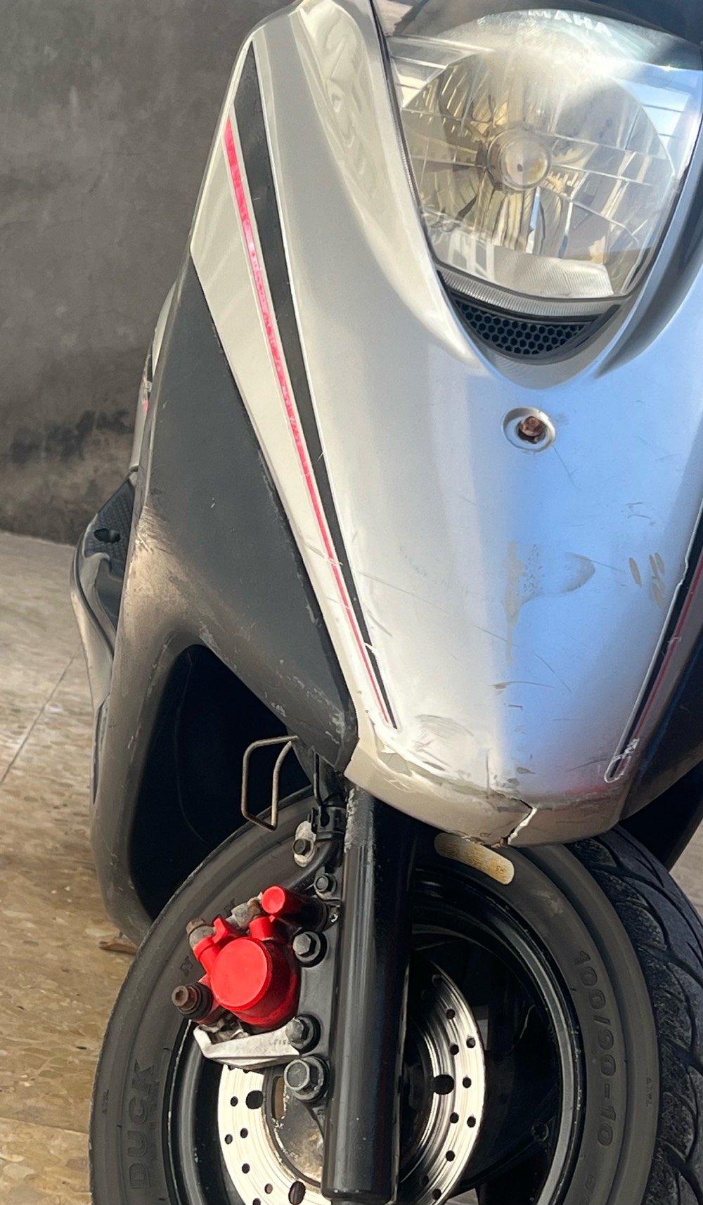 للبيع سكوتر ياماها نظيف ومجهز للاستخدام اليومي. السرعة تصل إلى 140 كم/س مع عداد قراءة على 90333 كم. تصميمه جذاب ولونه فضي مع تفاصيل حمراء. مناسب للتنقل في المدينة ومدى جيد للوقود. الفرامل والمصابيح بحالة جيدة.