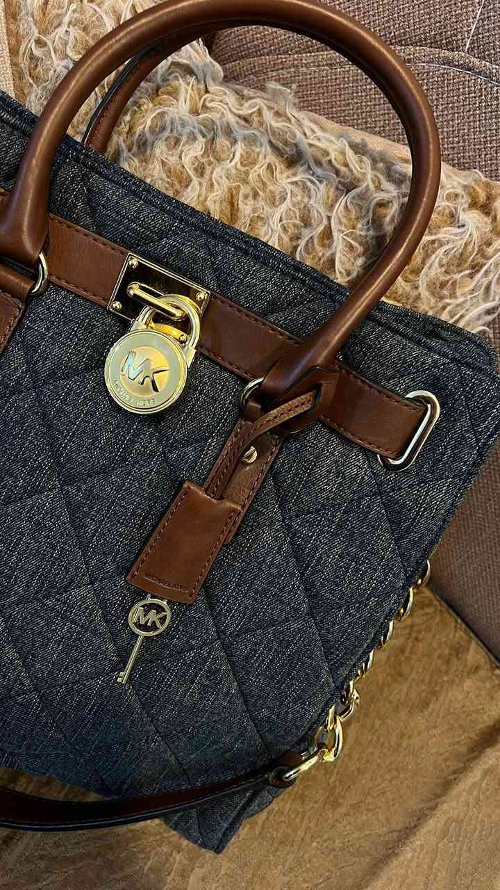 حقيبة مايكل كورس هاملتون هي حقيبة يد ساتشل/توت (Satchel/Tote) من تصميم العلامة التجارية Michael Kors. تتميز هذه النسخة بتصميمها المصنوع من قماش الجينز المبطن (Quilted Denim) باللون الأزرق مع مقابض وحواف من الجلد باللون البني

الميزات: تتميز الحقيبة بقفل معدني كلاسيكي يحمل شعار الماركة على الجهة الأمامية، وحمالات يد علوية، بالإضافة إلى حزام كتف قابل للتعديل والفصل مصنوع جزئيًا من سلسلة معدنية ذهبية اللون.

الحقيبة عملية ومرتبة، تسع الأغراض الأساسية اليومية بكل أناقة.
قطعة نادرة وغير متوفرة بكثرة، تناسب محبات القطع المختلفة والستايل الكلاسيكي العصري.
الحالة: ممتازة ✨
ا
القطعة ختم وكود
للتواصل خاص. :*********** واتساب فقط
