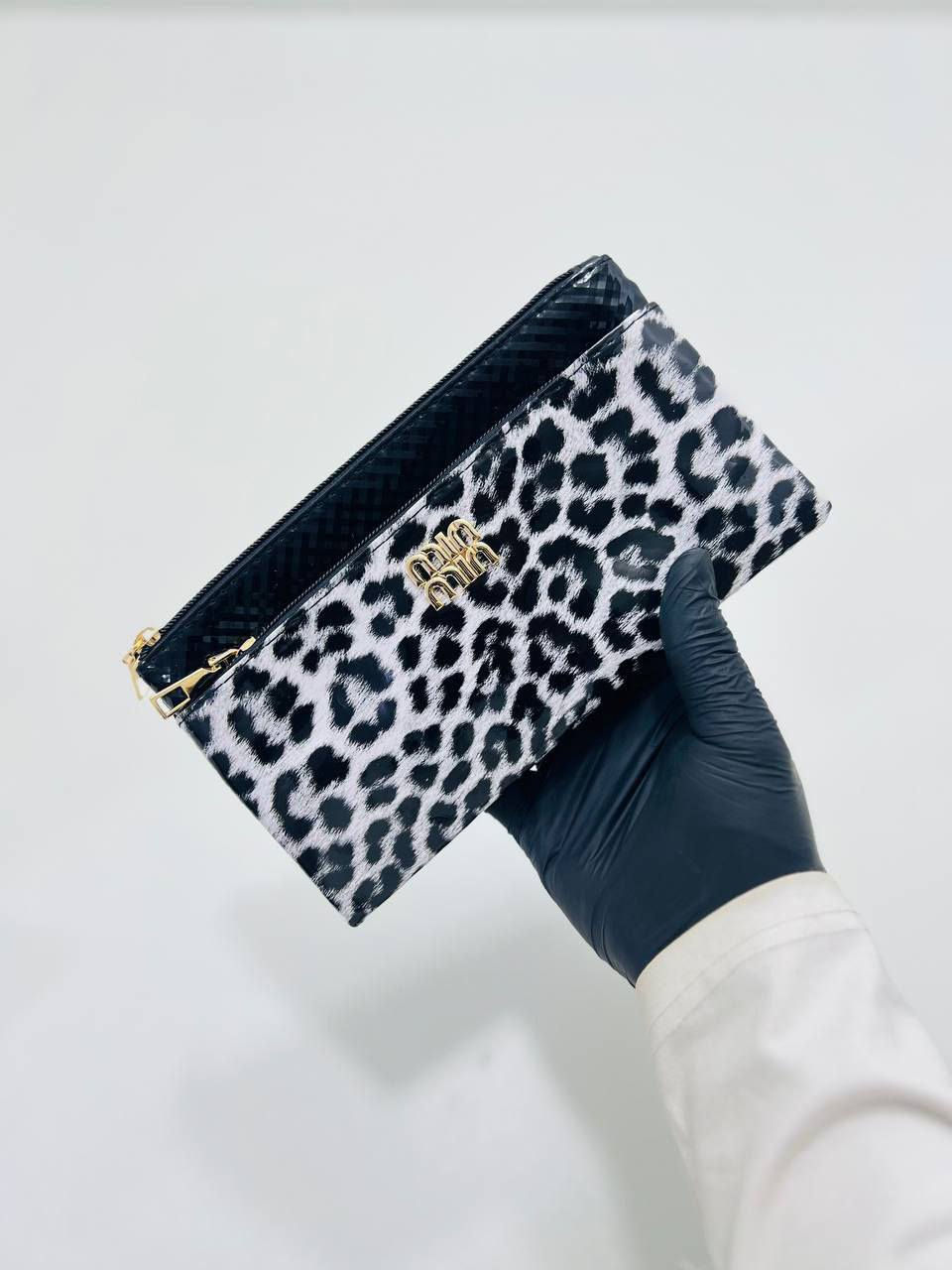 حقيبة كلاتش (Clutch) بنقشة جلد النمر. 
تتميز الحقيبة بالتالي:
التصميم: تأتي بنقشة جلد النمر (Leopard Print) باللونين الأبيض والأسود، مع جزء علوي أسود اللون.
الشعار: يتوسطها شعار ذهبي بارز.
الإغلاق: مزودة بسحاب علوي باللون الذهبي.
الاستخدام: تُستخدم عادةً كحقيبة يد صغيرة للمناسبات أو كحقيبة لتنظيم المكياج والمقتنيات الصغيرة داخل حقيبة أكبر.


**إذا كنت صاحب هذا الإعلان وتريد حذفه لأي سبب، رجاءا أرسل رسالة إلى الدعم الفني**