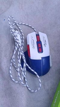 ماوس نظيف ومرتب، لونه أبيض/أزرق مع سلك مزخرف، ويبين عليه استخدام خفيف....