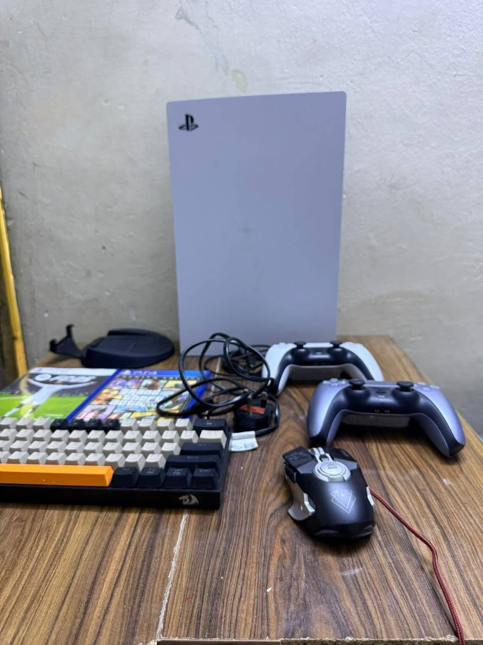 جهاز PlayStation 5 (النسخة الرقمية / وهو منصة الألعاب الشهيرة من شركة سوني. يالجهاز بتصميمه الانسيابي العمودي باللون الأبيض وإلى جانبه الملحقات المعروضة مثل أذرع التحكم اللاسلكية، لوحة مفاتيح ميكانيكية، 
وماوس والمعروض امامكم بلصورة
السعر 950
والرقم***********
