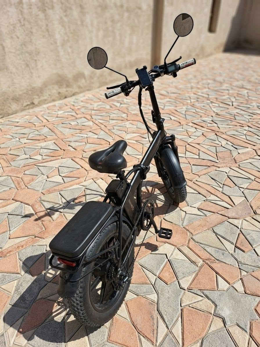 هذه الدراجة الظاهرة في الصورة هي دراجة كهربائية عريضة الإطارات وقابلة للطي (Folding Fat-Tire E-Bike) من العلامة التجارية LUTA (لوتا).
تتميز هذه الفئة من الدراجات بالعملية والقدرة على السير في الطرق الوعرة واليومية بفضل تصميمها المتين. إليك المواصفات التفصيلية للدراجة بناءً على تصميمها ومكوناتها الظاهرة:
​1. الهيكل والتصميم (Frame & Design)
​قابلية للطي: الدراجة تحتوي على قفل مفصلي في منتصف الهيكل، بالإضافة إلى إمكانية طي عمود المقود (الستيرن)، مما يسهل شحنها أو وضعها في صندوق السيارة.
​اللون: تأتي بلون أسود مطفي (Matte Black) مع شعار العلامة التجارية LUTA باللون الأحمر والأزرق.
​المقعد الخلفي: مزودة برف خلفي مدمج يحتوي على وسادة سميكة ومريحة (مسند مخصص لركوب شخص آخر أو لتثبيت الأغراض).
​المقعد الرئيسي: مقعد عريض ومريح ومبطن بشكل جيد لامتصاص الصدمات أثناء القيادة لمسافات طويلة، مع إمكانية تعديل الارتفاع.
​2. الإطارات والمساعدات (Wheels & Suspension)
​نوع الإطارات: إطارات عريضة جداً من نوع (Fat Tires) مخصصة لجميع التضاريس (الرمل، الحصى، الطرق الوعرة، والأسفلت) تمنح الدراجة ثباتاً ممتازاً.
​الجنوط: جنوط رياضية صلبة مصنوعة من الألمنيوم (شفرات/مراوح) وليست سيم (أسلاك)، وهي أكثر متانة وأقل حاجة للصيانة.
​المساعدات: تحتوي على مساعدات أمامية (Front Suspension Fork) لامتصاص الصدمات واهتزازات الطريق لضمان قيادة سلسة.
​مصدات الطين: رفارف (فندرات) أمامية وخلفية كاملة لحماية الراكب من رذاذ الماء أو الطين.
​3. النظام الكهربائي والميكانيكي (Electric & Mechanical System)
​المحرك: محرك كهربائي خلفي (Rear Hub Motor) مدمج في عجلة الدراجة الخلفية، (عادة في هذه الفئات تتراوح قوته بين 350 واط إلى 500 واط).
​البطارية: تقع في الصندوق المخصص أسفل المقعد مباشرة وفوق الدواسات، وهي محمية وقابلة للإزالة للشحن المنفصل بواسطة مفتاح أمان.
​نظام الكبح (الفرامل): مكابح قرصية (Disc Brakes) أمامية وخلفية لتوفير قوة كبح ممتازة واستجابة سريعة في مختلف الظروف الجوية.
​الدواسات: دواسات ميكانيكية عادية تتيح لك قيادة الدراجة كدراجة هوائية طبيعية في حال نفاد الشحن، أو استخدام نظام المساعدة

 على التبديل.

     لــلــبـيـع 《《《《《《 السعر 700 الف
ابوغريب عمارة الوزة.    ***********

هذه الدراجة الظاهرة في الصورة هي دراجة
 كهربائية عريضة الإطارات وقابلة للطي (Folding Fat-Tire E-Bike) من العلامة التجارية LUTA (لوتا).
