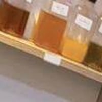 أبيع مجموعة زجاجات عطر/عطور ظاهرة بالصور، مرتبة على رف وبحالة نظيفة. إ...