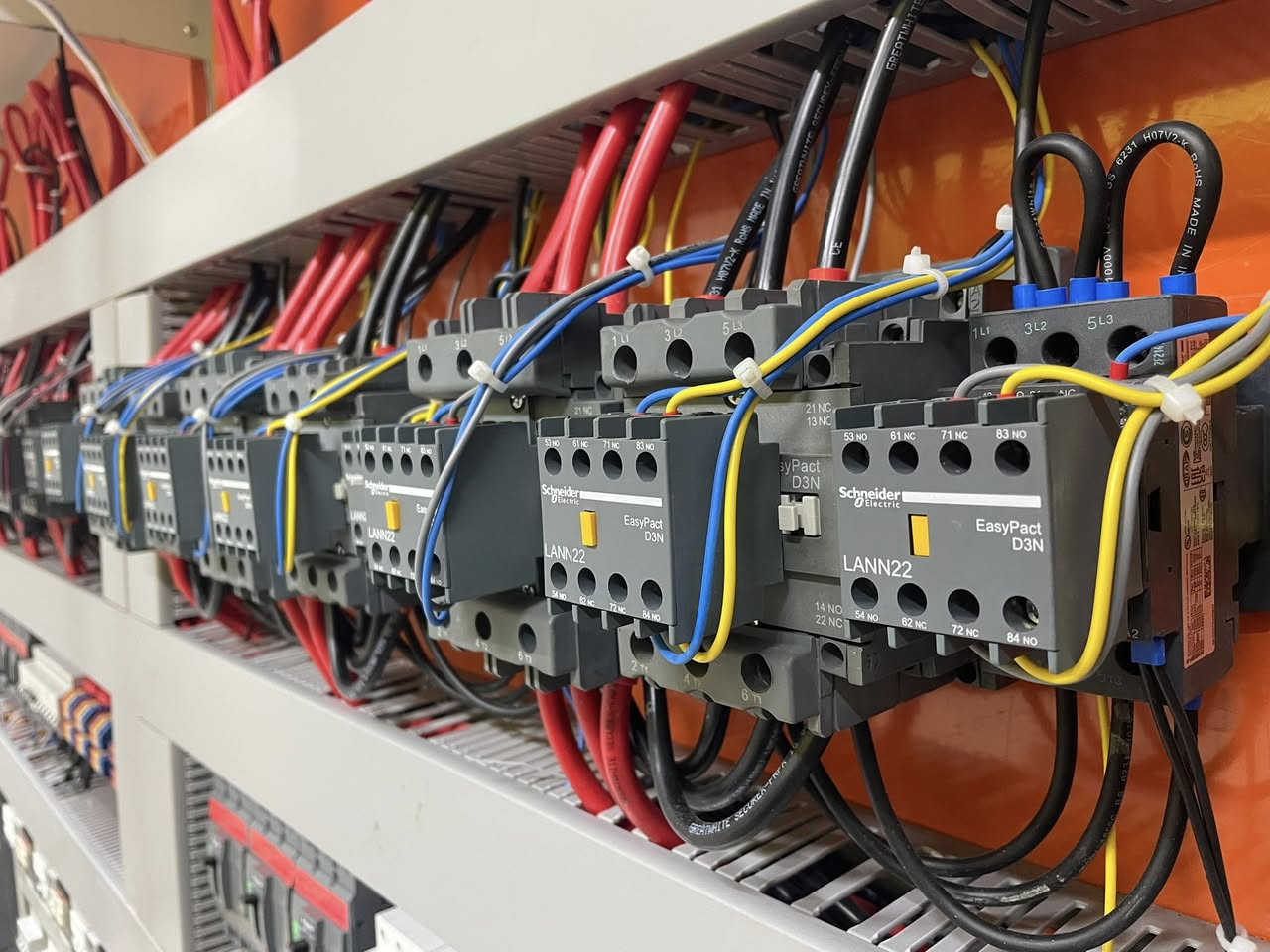 عندما تتحول موثوقية الطاقة إلى معيار هندسي مُحكم و ليس مجرد قرار تجاري عابر..

في المشاريع السكنية الحديثة ، إدارة الطاقة ليست مجرد تغذية كهربائية ، بل منظومة متكاملة من الاعتمادية ، السلامة ، و دقة القياس.
بتوفيق الله ، قمنا بتصميم و تصنيع لوحة تحويل تلقائي (Automatic Transfer Switch – ATS) متقدمة ، تعتمد على حلول Schneider Electric ، لتخدم عمارة سكنية مكونة من 7 وحدات مستقلة ، مع نظام تحويل آلي منفصل (Independent Automatic Transfer System) لكل شقة ، وفق أفضل الممارسات الهندسية العالمية.

⚡ البنية الهندسية للنظام | المواصفات الفنية : 
- تم تصميم و تنفيذ لوحة تحويل تلقائي (Automatic Transfer Switch – ATS) بهيكلية هندسية مدروسة و بأبعاد 200 × 140 سم ، قادرة على استيعاب الأحمال العالية مع ضمان توزيع طاقة متوازن (Balanced Load Distribution) و استقرار تشغيلي طويل الأمد.
- تعتمد المنظومة على مصدرَي تغذية رئيسيين : 
❶ مصدر الشبكة الوطنية (Utility Power Source) 
❷ مصدر المولد الاحتياطي (Backup Generator Source)
وذلك عبر قاطعَي دخول رئيسيين بسعة (400A) لضمان موثوقية التحويل و استمرارية التغذية.
- منظومة تحويل مستقلة : تم اعتماد نظام تحويل آلي مستقل (Independent Automatic Transfer System) لكل شقة من خلال لوحة ATS منفصلة تضمن الفصل الكامل بين الوحدات السكنية (إدارة الطاقة لكل شقة بشكل مستقل) ، و تتكون كل لوحة ATS من خمسة مكونات رئيسية :
❶ قاطع دخول رئيسي (MCCB 100A)
❷ قاطع حماية ثلاثي (MCB 63A)
❸ كونتكتر رئيسي (Main Contactor 125A)
❹ كونتكتر تحويل (Transfer Contactor 80A)
❺ كونتكتر خط السحب (Load Shedding Contactor 25A)
- فلسفة الحماية و التحكم : تم تطوير منظومة الحماية و التحكم وفق فلسفة هندسية مدروسة ، تهدف إلى ضمان استقرار النظام الكهربائي و حماية الأحمال و منع أي تداخل غير مرغوب بين مصادر التغذية ، و ابرز مكونات الرئيسية هي :
❶ جهاز حماية الجهد الكهربائي 
(Over / Under Voltage Protection Relay)
❷ مؤقت زمني (2 × Time Delay Relays) للتحكم بتسلسل التحويل و تقليل الصدمات الكهربائية و منع التداخل بين مصادر التغذية.

⚡ القيمة التشغيلية | الفوائد المحققة :
• حماية شاملة للأحمال من تيار الحمل الزائد (Overload Current) و تيار القصر الكهربائي (Short Circuit Current) عبر منظومة القواطع الرئيسية و الفرعية ، بما يضمن الفصل الفوري للأعطال و منع ارتفاع درجات الحرارة أو تلف المكونات.
• حماية الجهد الكهربائي من الارتفاع و الانخفاض (Over / Under Voltage Protection) فيما يخص الشبكة الوطنية ، لمنع تلف الأجهزة الحساسة الناتج عن عدم استقرار الفولتية.
• منع التداخل بين مصادر التغذية (Source Interlocking Protection) مع حماية الأحمال أثناء التحويل عبر تسلسل زمني مدروس (Time Delay Transfer Logic) بأستخدام تايمرات زمنية (Time Delay Relays) ، بما يضمن عدم تزامن الشبكة الوطنية مع المولد و تقليل الصدمات الكهربائية أثناء الانتقال بين المصادر.
• يوفر النظام فصل كامل للأحمال بين الوحدات السكنية عبر نظام تحويل مستقل (Independent ATS System) ، مما يمنع انتقال الأعطال بين الشقق ، و يتيح قياس استهلاك الطاقة لكل شقة بدقة عالية ، مع الامتثال الكامل لمتطلبات السلامة التشغيلية العامة للمباني السكنية متعددة الوحدات.

⚡ مجالات التطبيق | الاستخدامات :
• المجمعات السكنية.  
• الأبنية الاستثمارية.
• المباني المعتمدة على أنظمة مولدات احتياطية.
• المشاريع التي تتطلب أنظمة (ATS) مستقلة مع قياس استهلاك طاقة دقيق.

في #عصر_الأتمتة ، نعمل برسالة هندسية ، لا بغاية ربحية..

⚡ نفتخر بتقديم حلولاً مبتكرة في تصميم و تصنيع اللوحات الكهربائية للمشاريع السكنية و الصناعية ، مع ضمان جودة يؤكد التزامنا الصارم بالمواصفات الأوروبية في كل تفصيلة ، حيث أن جميع لوحاتنا مطابقة لمعايير IEC 61439 و IEC 60947 و معتمدة بعلامة CE الأوروبية ، لضمان أعلى مستويات السلامة و الاعتمادية ، كما نُؤكد علىٰ عدم تعاملنا بالمواد الغير اصلية (المقلدة) حتى لو كان ذلك بطلب من العميل نفسه !
⚡ خدماتنا تشمل :
• دعم فني حقيقي مقدم من فريق مُهندسين عالي المهارة.
• توصيل مباشر الى الموقع مع تركيب احترافي.
• صيانة موقعية موثوقة.
• توفير قطع غيار اصلية.

قسم التصميم (اتصال + واتساب) : ‭0787 980 1800‬
الدعم الفني :
eng.hussein_qasim_kadhim@yahoo.com
الادارة : automation.era@yahoo.com
العنوان : بغداد / الشورجة / عكد النصارى / قرب مطعم العمار

#لوحات_التحويل_التلقائي
#لوحات_توزيع_رئيسية
#أنظمة_الطاقة_السكنية  
#أنظمة_قدرة_موثوقة 
#حلول_كهربائية_متقدمة 
#شنايدر_الكتريك 
#ATSPanel 
#MDBPanel
#SmartElectricalBoards 
#ResidentialPowerSystems 
#AutomaticEnergyControl 
#LoadProtectionSolutions 
#BackupPowerManagement 
#ReliableEnergyDistribution
