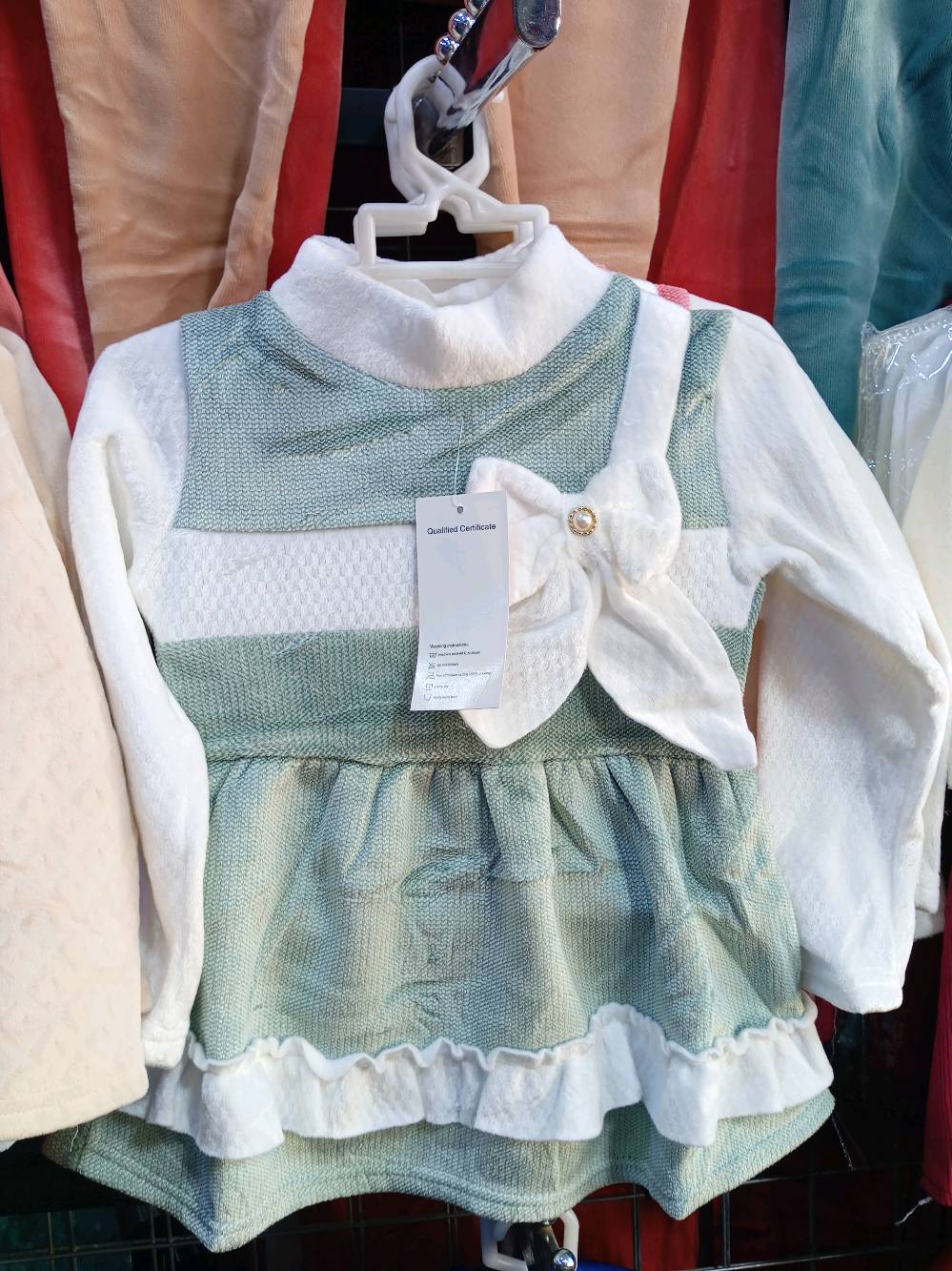 ملابس أطفال جميلة ومريحة لفصل الشتاء، تتضمن قطعتين بألوان مختلفة. الفستان الأول بلون أحمر مع تحتية بيضاء، والثاني بلون أخضر فاتح مع تفاصيل زهرة. خامة ناعمة ومناسبة للبرد. مثالية لإطلالات يومية أو للمناسبات الخاصة.