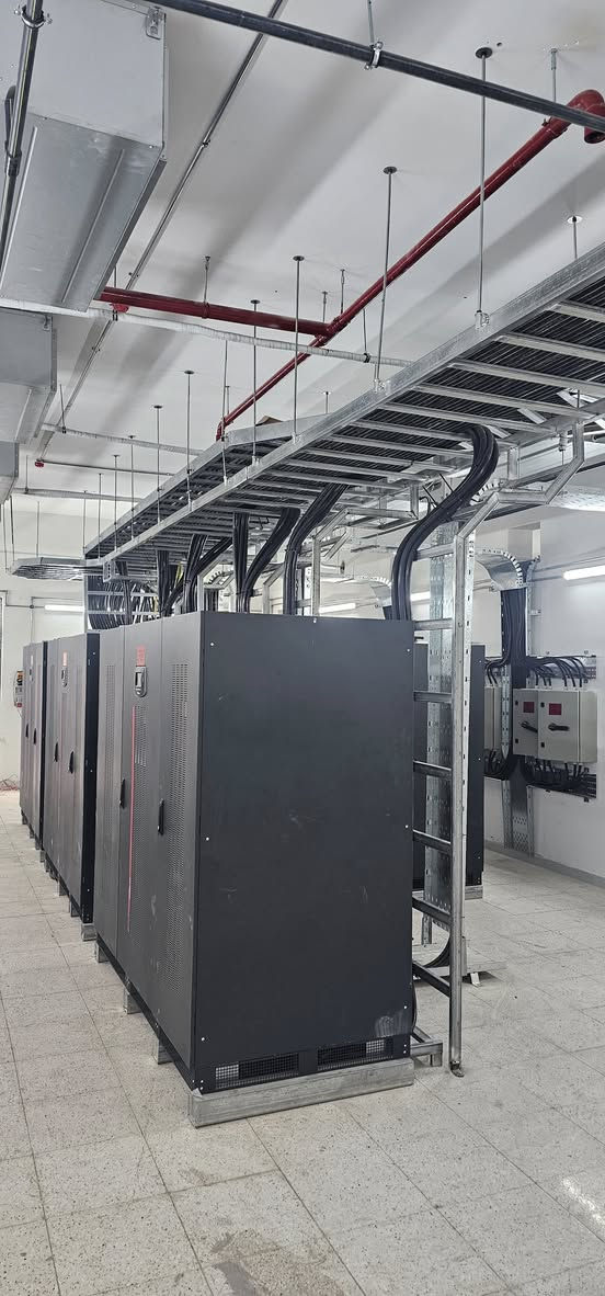 🏢 تم بعونه تعالى إنجاز مشروع الشركة المتكاملة تجهيز وتنصيب منظومة طاقة غير منقطعة (UPS) متكاملة من شركة Riello UPS الإيطالية، باستخدام أجهزة موديل MHT600 وبسعة 600 KVA للجهاز الواحد.
⚡ تم ربط عدد (5) أجهزة بنظام التوازي (Parallel System) لتشكيل منظومة مركزية متكاملة بسعة إجمالية تبلغ :
🔹 3000 KVA
🔋 كما تم تجهيز المنظومة ببطاريات صناعية نوع Lead Acid من شركة Leoch العالمية، لضمان أعلى مستويات الاعتمادية والاستقرار واستمرارية التغذية الكهربائية للأحمال الحساسة والمشاريع الحيوية.
🛠️ شملت الأعمال :
✔️ التجهيز الكامل للمعدات
✔️ أعمال التنصيب والربط
✔️ البرمجة والتشغيل
✔️ إجراء الفحوصات الفنية والاختبارات التشغيلية وفق المعايير العالمية
📈 تتميز منظومات MHT Series بالكفاءة العالية، وقابلية التوسع، والاعتمادية الكبيرة في التطبيقات الصناعية ومراكز البيانات والمشاريع الحرجة.
📞 للاستفسار والتواصل :
***********
🏢 شركة عجائب الماس
الوكلاء المعتمدون لشركة Riello UPS في العراق 🇮🇶

