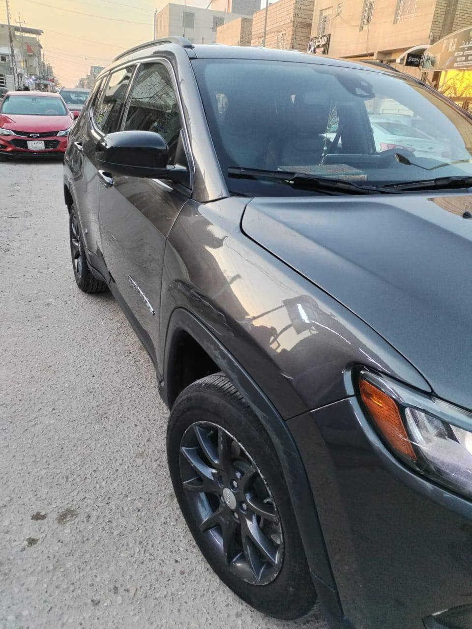 سيارة SUV مدمجة بتصميم عصري، أداء قوي، متكاملة، جيب كومباس لاتيتيود 2023. السيارة وارد أمريكا، وتم تصليحها باحتراف وهي الآن بحالة ممتازة وجاهزة للاستخدام.

⸻

 المواصفات العامة:
 • الموديل: جيب كومباس لاتيتيود (Latitude)
 • السنة: 2023
 • اللون: رمادي معدني (Metallic Gray)
 • بلد المنشأ: وارد أمريكا
 • المسافة المقطوعة: 56000 كم)
 • الحالة: تم تصليحها بالكامل بعد حادث، وتم ترخيصها وتسجيلها في العراق

⸻

 الأداء والمحرك:
 • المحرك: 2.4 لتر، 4 سلندر Tigershark MultiAir 2
 • القوة الحصانية: 180 حصان
 • ناقل الحركة: أوتوماتيكي بـ 9 سرعات
 • نظام الدفع: دفع رباعي (4X4)
 • استهلاك الوقود: اقتصادي، ما بين 7.8 - 9.5 لتر لكل 100 كم

⸻

 التصميم الخارجي:
 • شبك جيب الأيقوني بسبع فتحات مع لمسات كرومية
 • مصابيح أمامية وخلفية LED بالكامل مع إضاءة نهارية DRL
 • عجلات رياضية سوداء قياس 18 إنش
 • سقف بانورامي متوفر في بعض الفئات
 • باب خلفي لسهولة التحميل

⸻

 الداخلية والراحة:
 • عدد المقاعد: 5 مقاعد بتصميم مريح
 • الخامة: مقاعد جلدية فاخرة
 • المقاعد الأمامية: قابلة للتعديل كهربائيًا بـ 8 وضعيات
 • التدفئة: المقاعد الأمامية مزودة بـ خاصية التدفئة
 • التكييف: نظام تحكم بالمناخ ثنائي المناطق
 • نظام المعلومات والترفيه:
 • شاشة لمس 10.1 إنش
 • Apple CarPlay و Android Auto
 • نظام صوتي فاخر
 • منافذ USB-A و USB-C في الأمام والخلف
 • كاميرا رؤية خلفية مع حساسات

⸻

 أنظمة الأمان والمساعدة:

 نظام الكبح التلقائي في حالات الطوارئ
 مساعد البقاء في المسار
 تنبيه النقطة العمياء
 مثبت سرعة متكيف مع ميزة التوقف والانطلاق
 حساسات أمامية وخلفية لصف السيارة
 نظام مراقبة ضغط الإطارات

⸻

   

 مكان السياره كربلاء ***********
