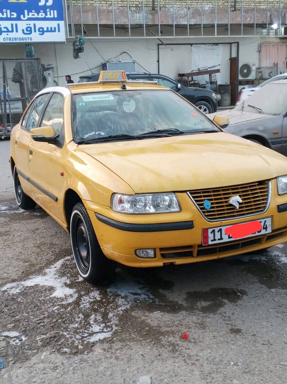 سيارة تاكسي صفراء معروضة للبيع، بحالة جيدة ومستعدة للعمل مباشرة. جسم السيارة نظيف ومصبوغ باللون الأصفر اللامع لتكون مرئية وواضحة في الشوارع.
