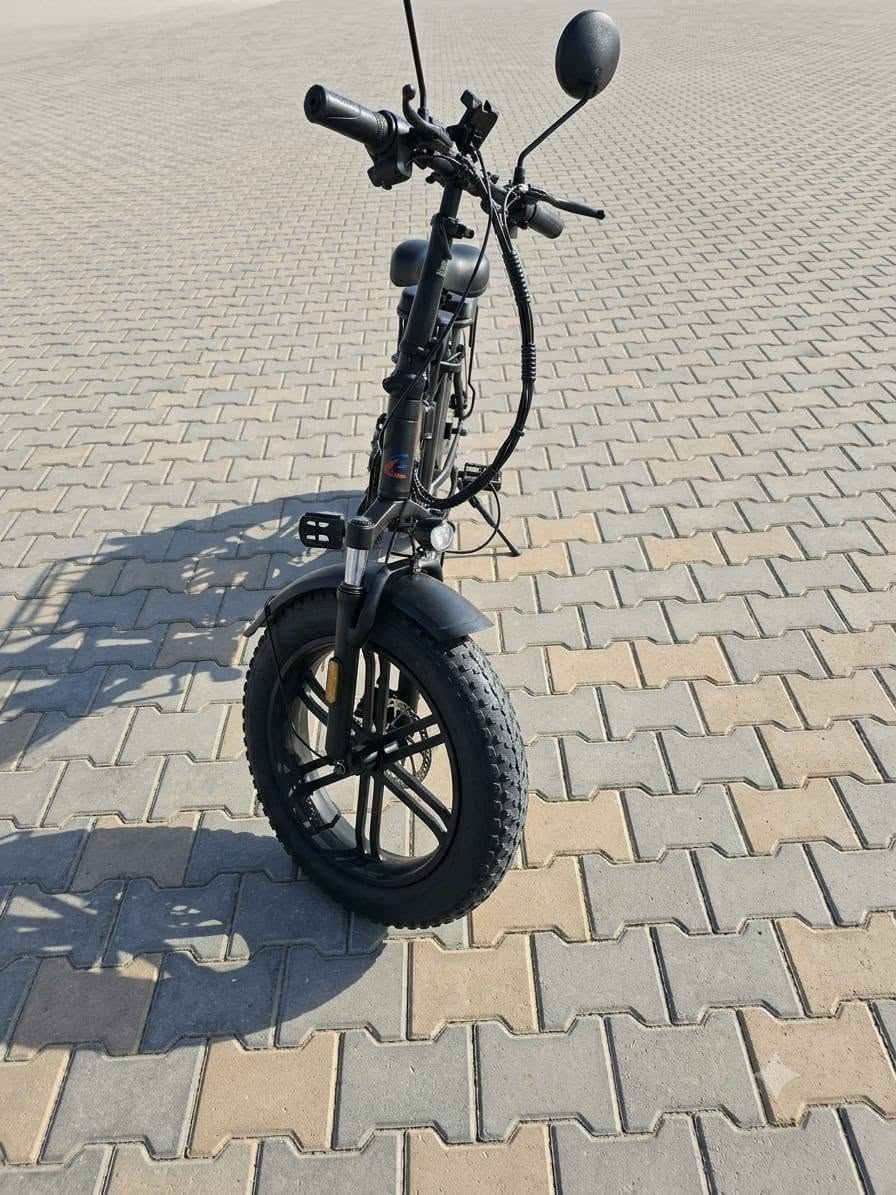 هذه الدراجة الظاهرة في الصورة هي دراجة كهربائية عريضة الإطارات وقابلة للطي (Folding Fat-Tire E-Bike) من العلامة التجارية LUTA (لوتا).
تتميز هذه الفئة من الدراجات بالعملية والقدرة على السير في الطرق الوعرة واليومية بفضل تصميمها المتين. إليك المواصفات التفصيلية للدراجة بناءً على تصميمها ومكوناتها الظاهرة:
​1. الهيكل والتصميم (Frame & Design)
​قابلية للطي: الدراجة تحتوي على قفل مفصلي في منتصف الهيكل، بالإضافة إلى إمكانية طي عمود المقود (الستيرن)، مما يسهل شحنها أو وضعها في صندوق السيارة.
​اللون: تأتي بلون أسود مطفي (Matte Black) مع شعار العلامة التجارية LUTA باللون الأحمر والأزرق.
​المقعد الخلفي: مزودة برف خلفي مدمج يحتوي على وسادة سميكة ومريحة (مسند مخصص لركوب شخص آخر أو لتثبيت الأغراض).
​المقعد الرئيسي: مقعد عريض ومريح ومبطن بشكل جيد لامتصاص الصدمات أثناء القيادة لمسافات طويلة، مع إمكانية تعديل الارتفاع.
​2. الإطارات والمساعدات (Wheels & Suspension)
​نوع الإطارات: إطارات عريضة جداً من نوع (Fat Tires) مخصصة لجميع التضاريس (الرمل، الحصى، الطرق الوعرة، والأسفلت) تمنح الدراجة ثباتاً ممتازاً.
​الجنوط: جنوط رياضية صلبة مصنوعة من الألمنيوم (شفرات/مراوح) وليست سيم (أسلاك)، وهي أكثر متانة وأقل حاجة للصيانة.
​المساعدات: تحتوي على مساعدات أمامية (Front Suspension Fork) لامتصاص الصدمات واهتزازات الطريق لضمان قيادة سلسة.
​مصدات الطين: رفارف (فندرات) أمامية وخلفية كاملة لحماية الراكب من رذاذ الماء أو الطين.
​3. النظام الكهربائي والميكانيكي (Electric & Mechanical System)
​المحرك: محرك كهربائي خلفي (Rear Hub Motor) مدمج في عجلة الدراجة الخلفية، (عادة في هذه الفئات تتراوح قوته بين 350 واط إلى 500 واط).
​البطارية: تقع في الصندوق المخصص أسفل المقعد مباشرة وفوق الدواسات، وهي محمية وقابلة للإزالة للشحن المنفصل بواسطة مفتاح أمان.
​نظام الكبح (الفرامل): مكابح قرصية (Disc Brakes) أمامية وخلفية لتوفير قوة كبح ممتازة واستجابة سريعة في مختلف الظروف الجوية.
​الدواسات: دواسات ميكانيكية عادية تتيح لك قيادة الدراجة كدراجة هوائية طبيعية في حال نفاد الشحن، أو استخدام نظام المساعدة

 على التبديل.

     لــلــبـيـع 《《《《《《 السعر 700 الف
ابوغريب عمارة الوزة.    ***********

هذه الدراجة الظاهرة في الصورة هي دراجة
 كهربائية عريضة الإطارات وقابلة للطي (Folding Fat-Tire E-Bike) من العلامة التجارية LUTA (لوتا).
