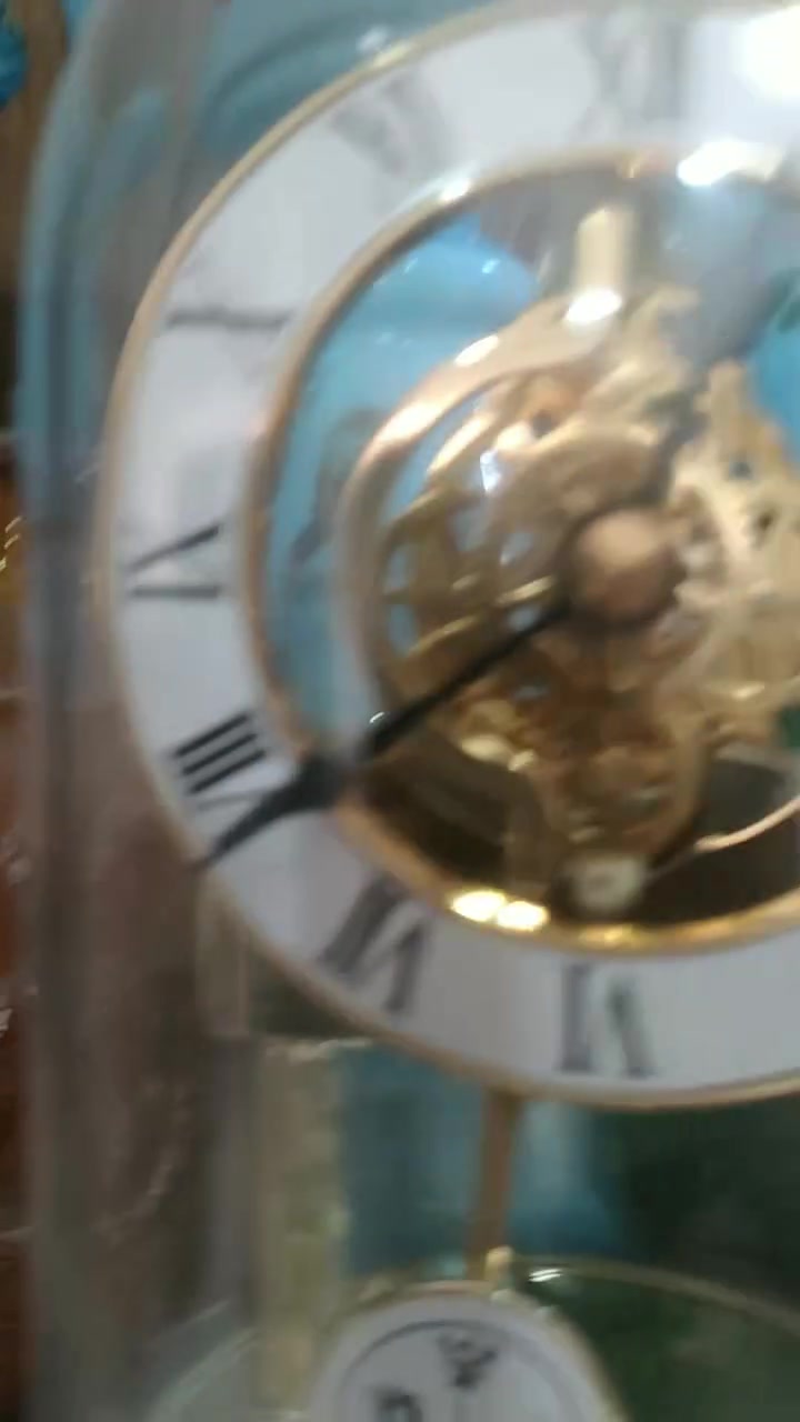 ***********
ساعة طاولة عتيقة من طراز Kundo Quartz Torsion، وتتميز بغطاء زجاجي واقٍ.تحتوي الساعة على حركة مرئية تعمل بالبطارية، مع قرص ذو أرقام رومانية وشعار  ريذم
